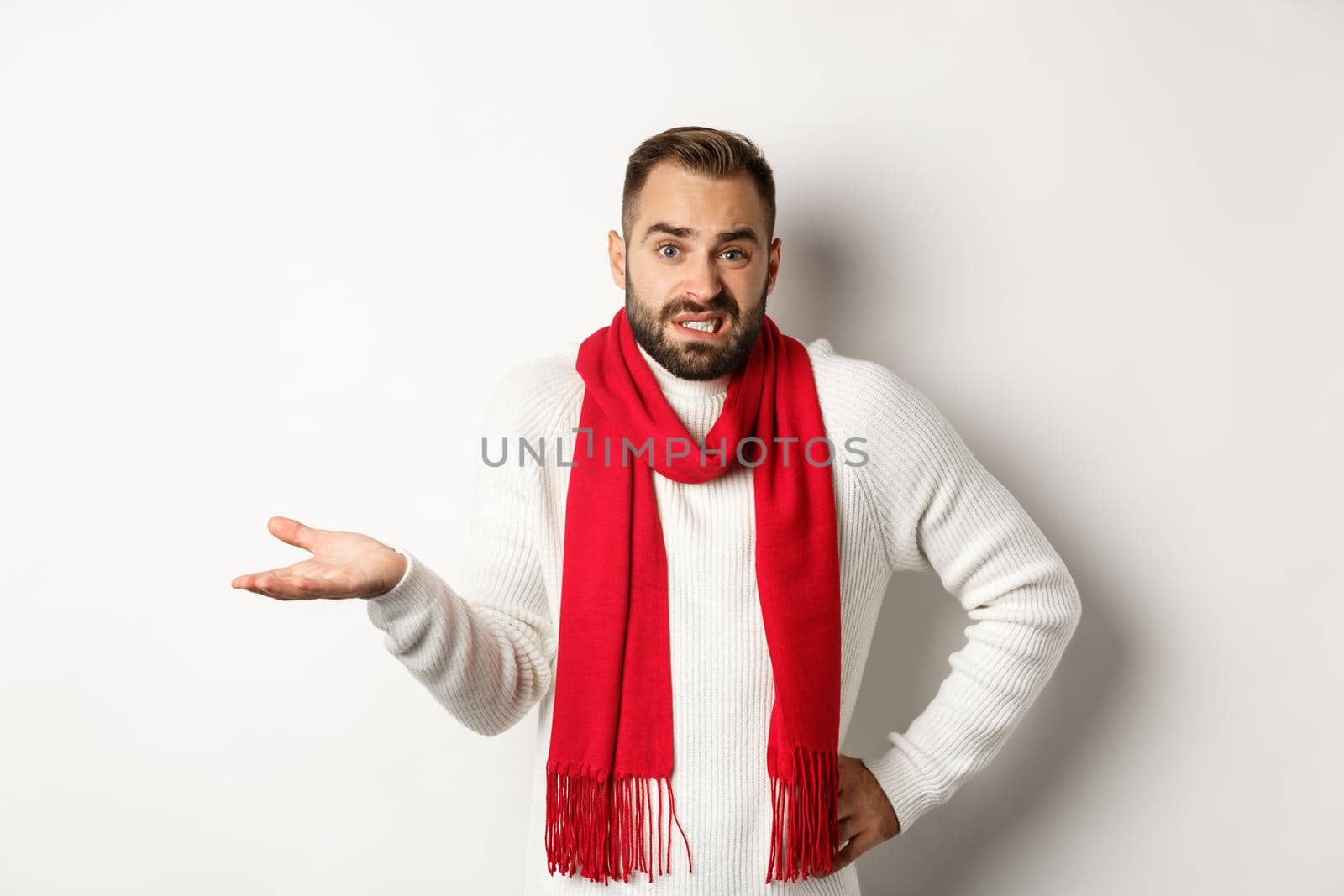 Clueless bearded man dont know, shrugging and saying sorry, standing puzzled against white background.