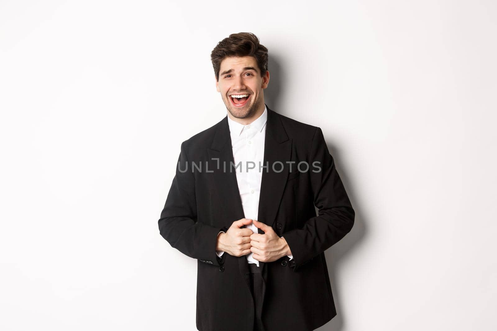 Concept of new year party, celebration and lifestyle. Portrait of handsome and confident man in suit, smiling pleased, feeling successful, standing over white background by Benzoix