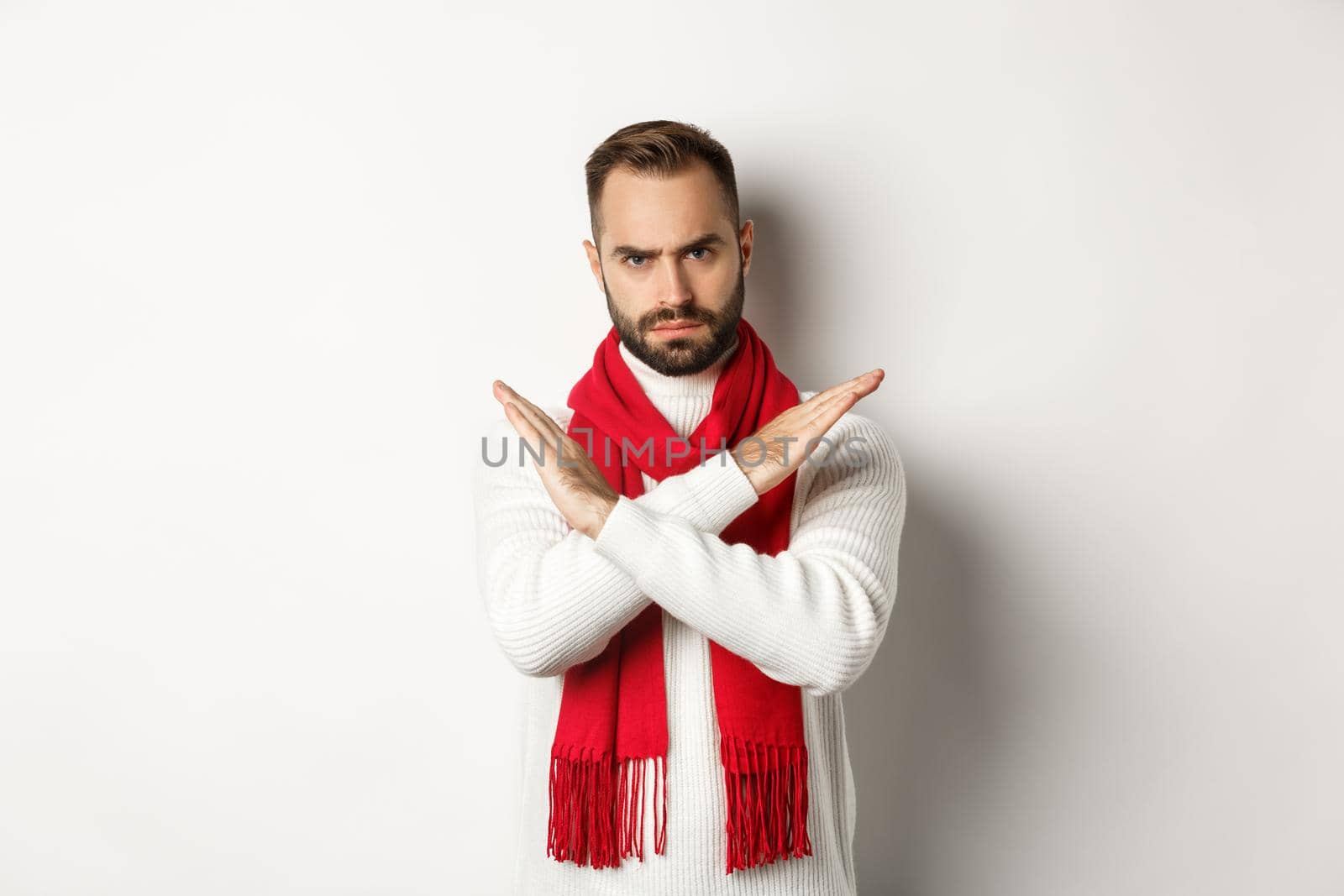 Angry bearded man frowning, showing cross stop gesture, telling no, forbid something bad, standing over white background.