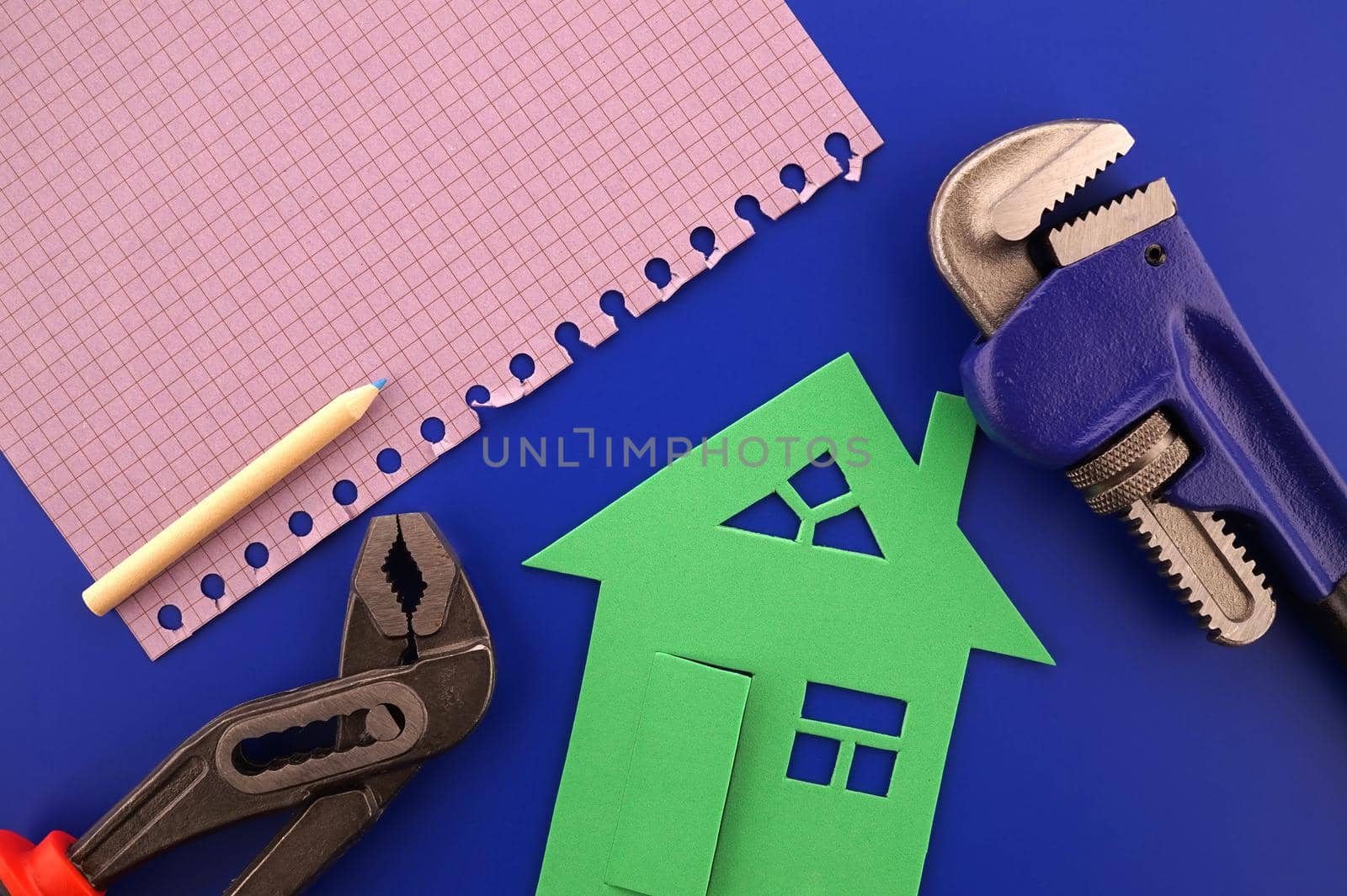 House ownership, building or construction still life concept with a flat lay of notebooks, wrench, purse, pencil and colorful cutout paper homes