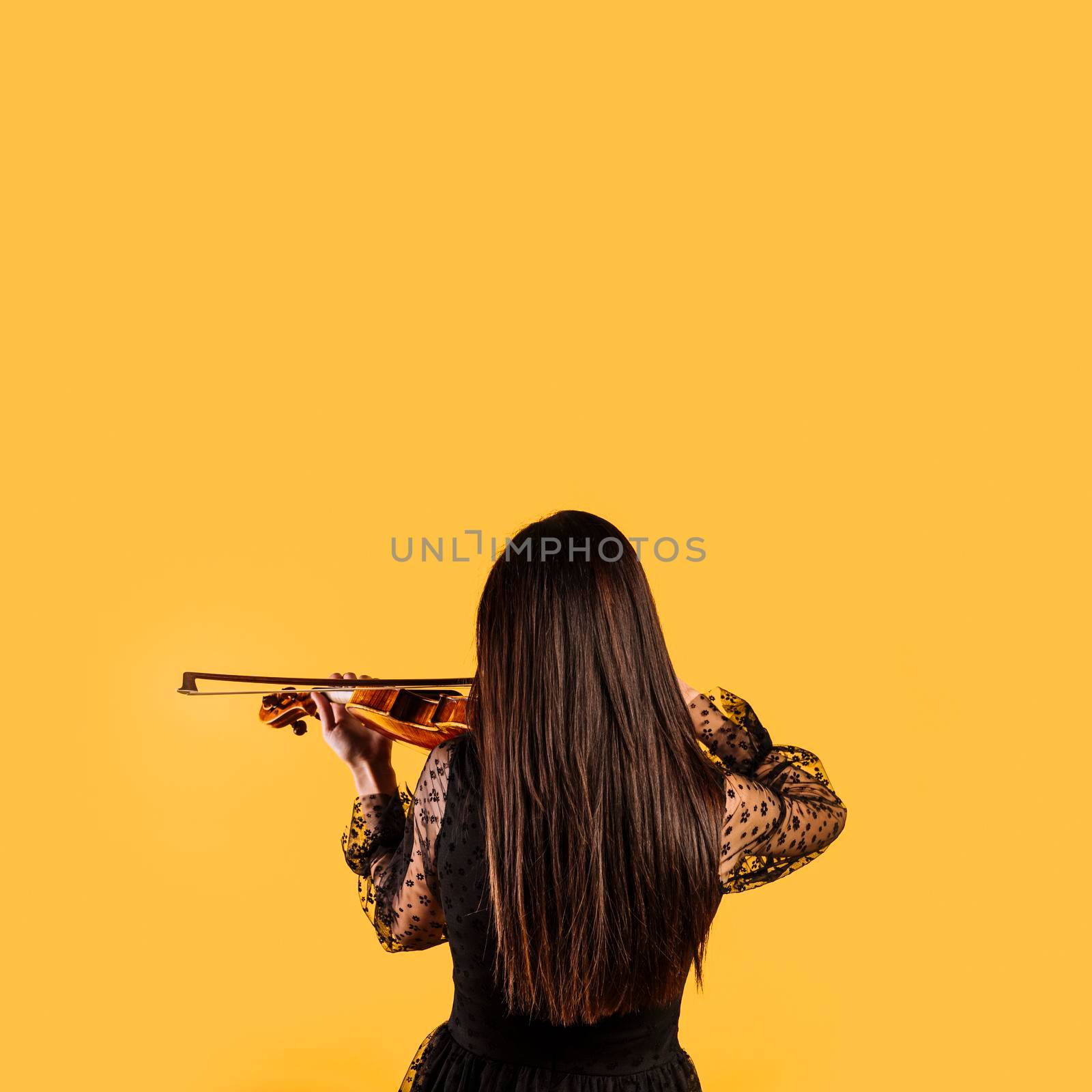 girl showing her back playing violin. High quality photo by Zahard