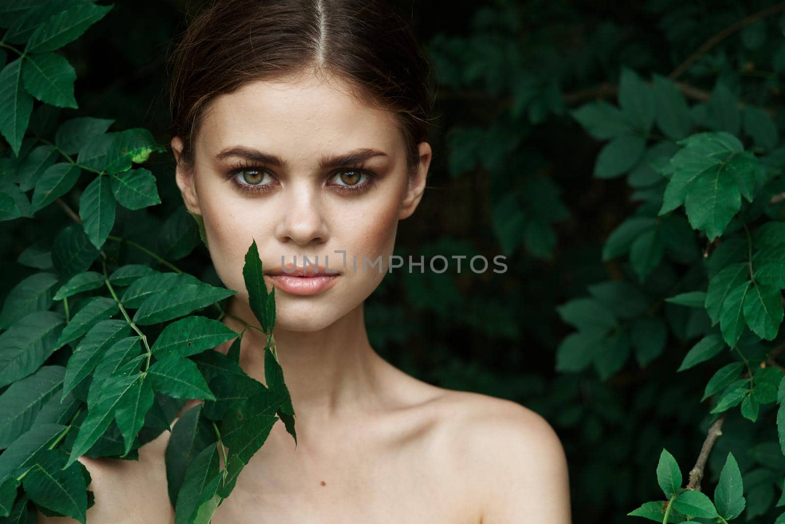 attractive woman skin care bare shoulders green leaves nature model. High quality photo