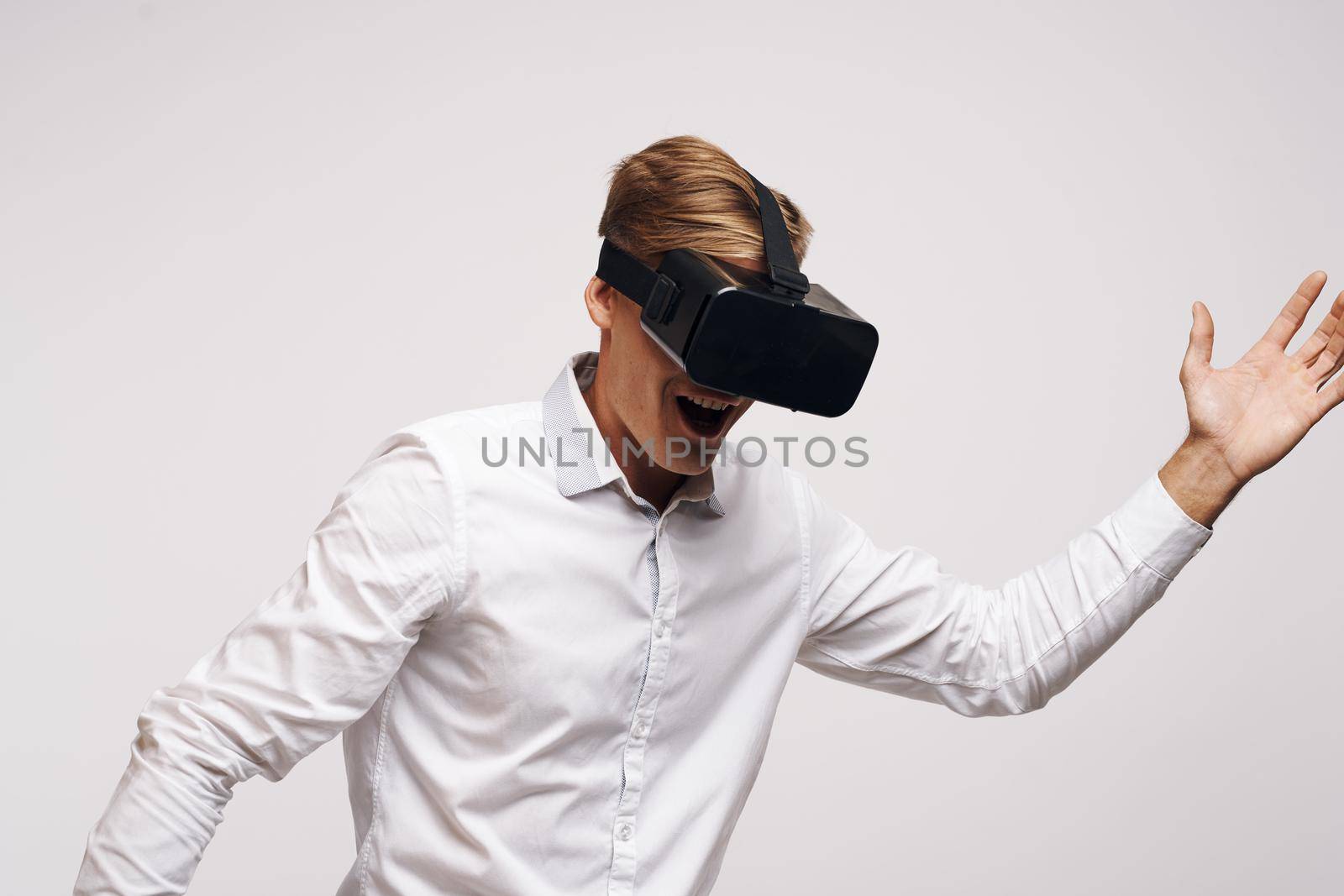 portrait of a man in a white shirt vr glasses gadget device video technology studio. High quality photo