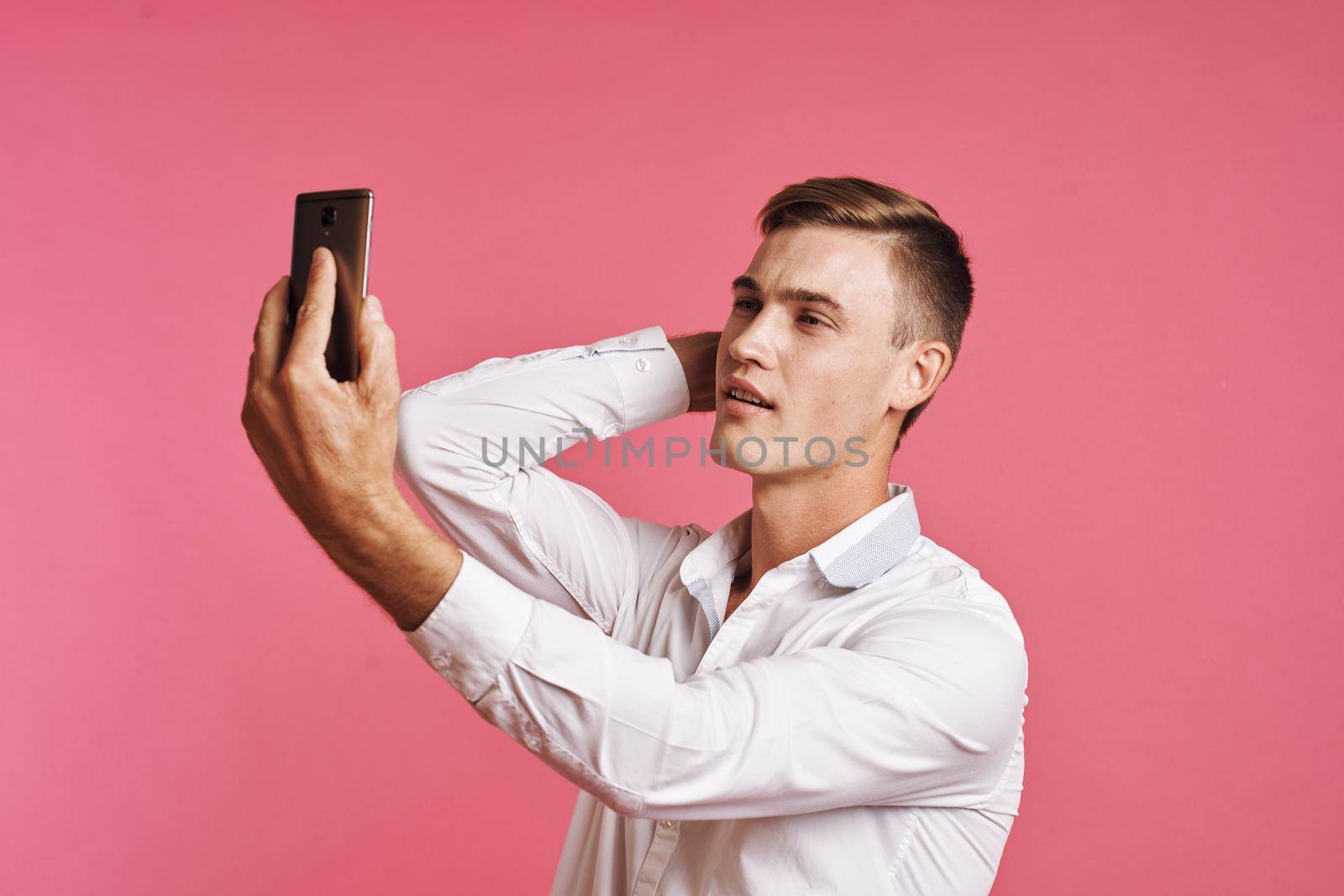 businessmen with a phone in hand fashion posing pink background by Vichizh