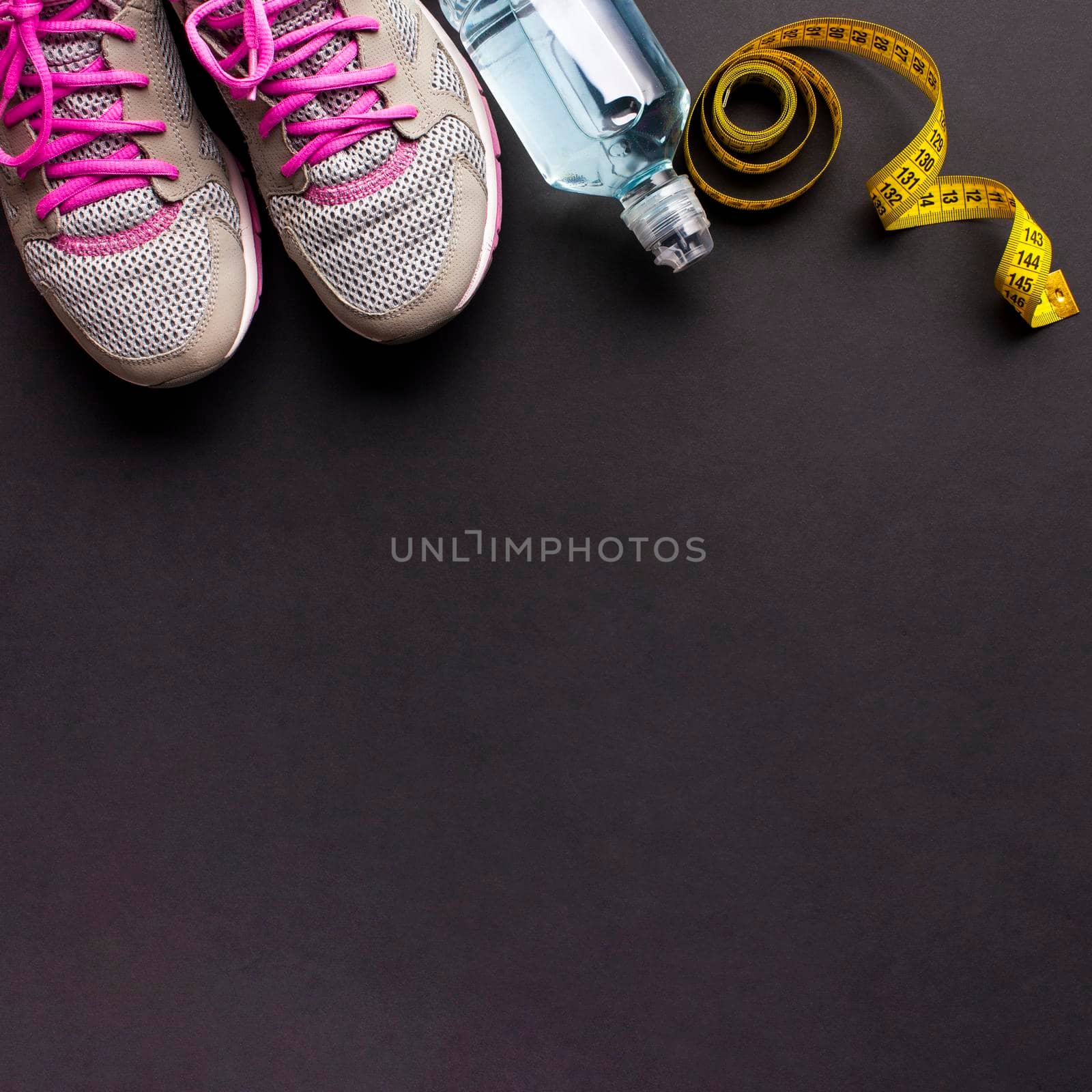 arrangement with running shoes water bottle. High resolution photo