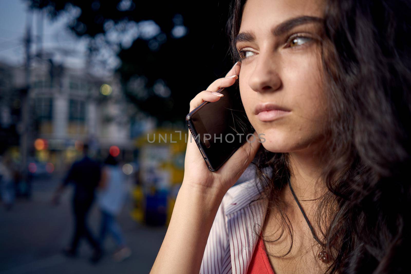 woman talking on the phone outdoors walking in the evening on the street. High quality photo