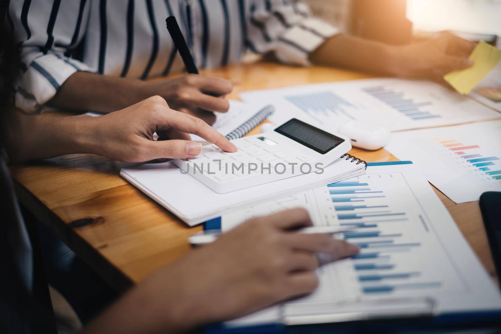 During a business meeting with colleagues, a company marketologist gives a presentation about market plan and investment and pointing at paperwork.