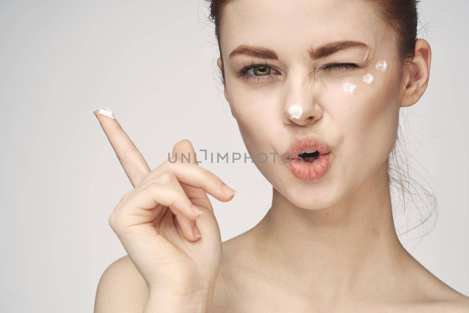 woman with face cream naked shoulders cosmetics face care. High quality photo