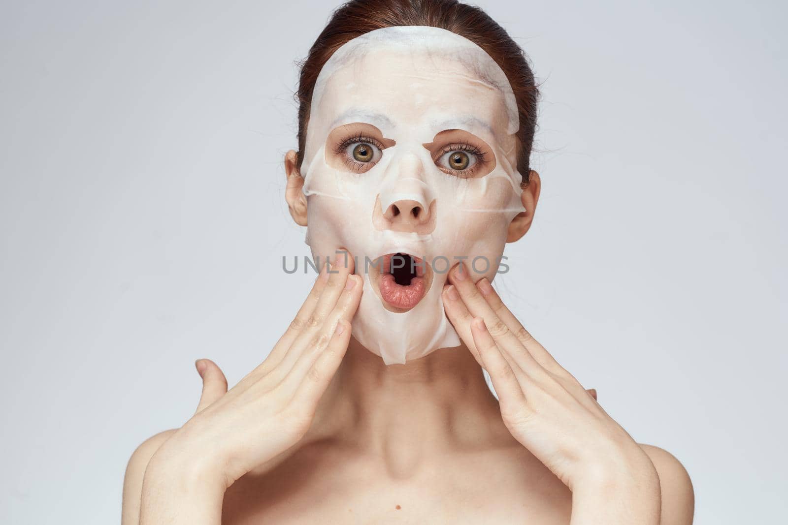 emotional woman cosmetic face mask close-up light background by Vichizh