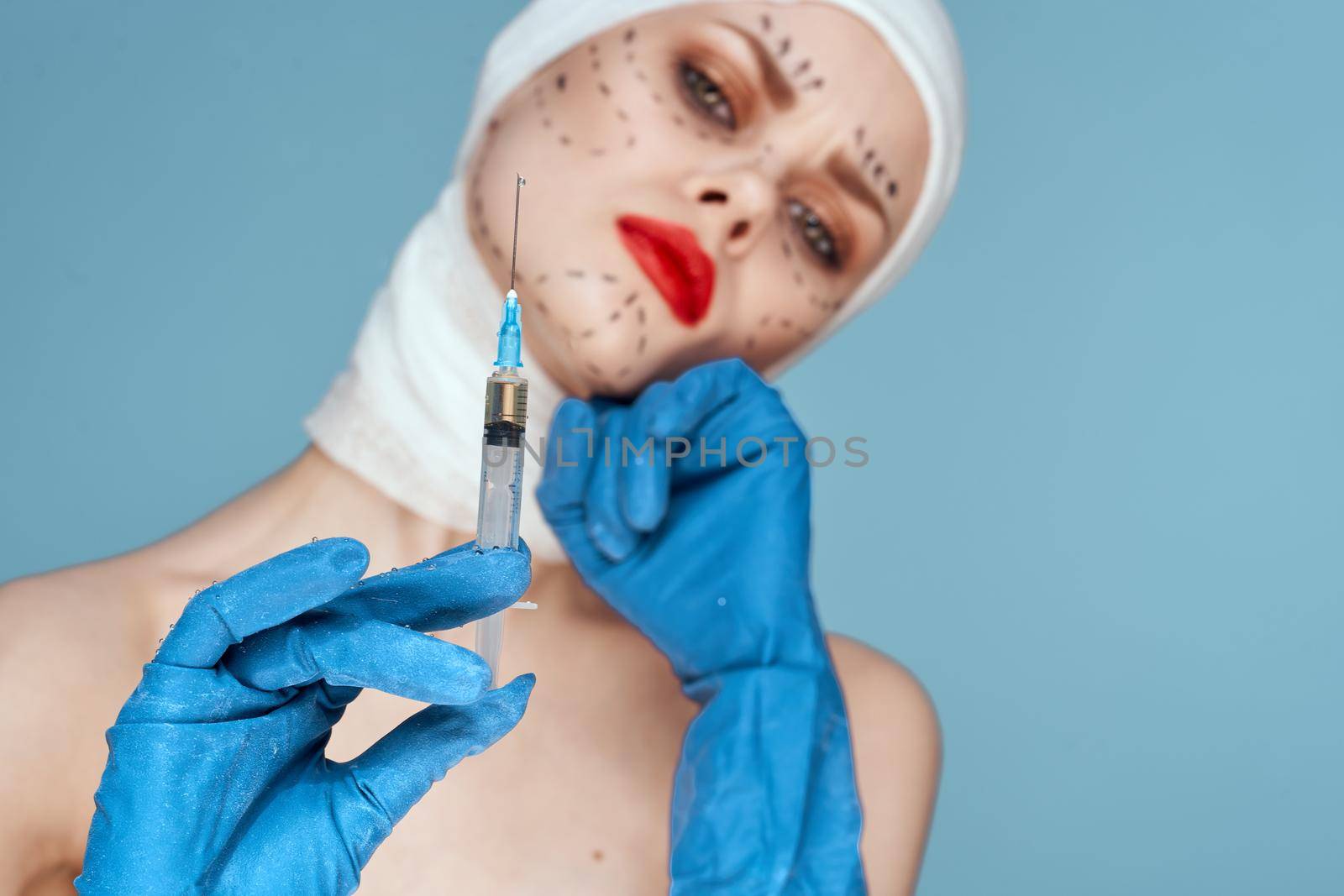 beautiful woman in blue gloves syringe in hands contour on the face lifting isolated background. High quality photo