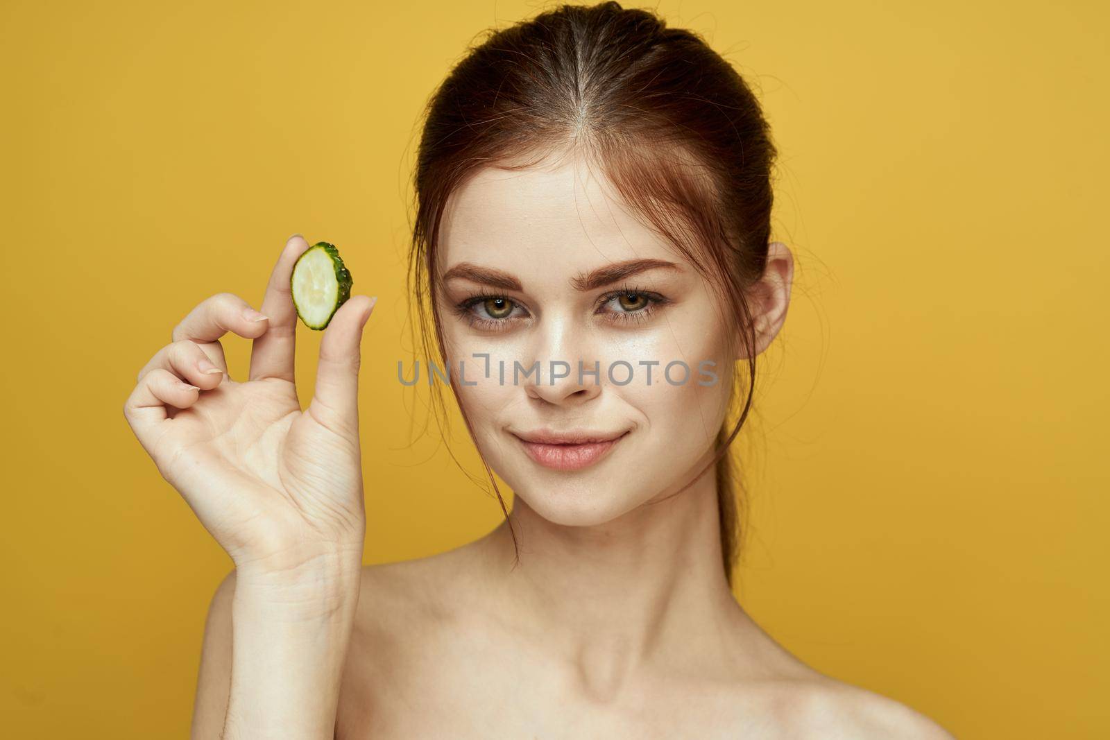 cheerful woman with cucumber vitamin skin care natural product. High quality photo