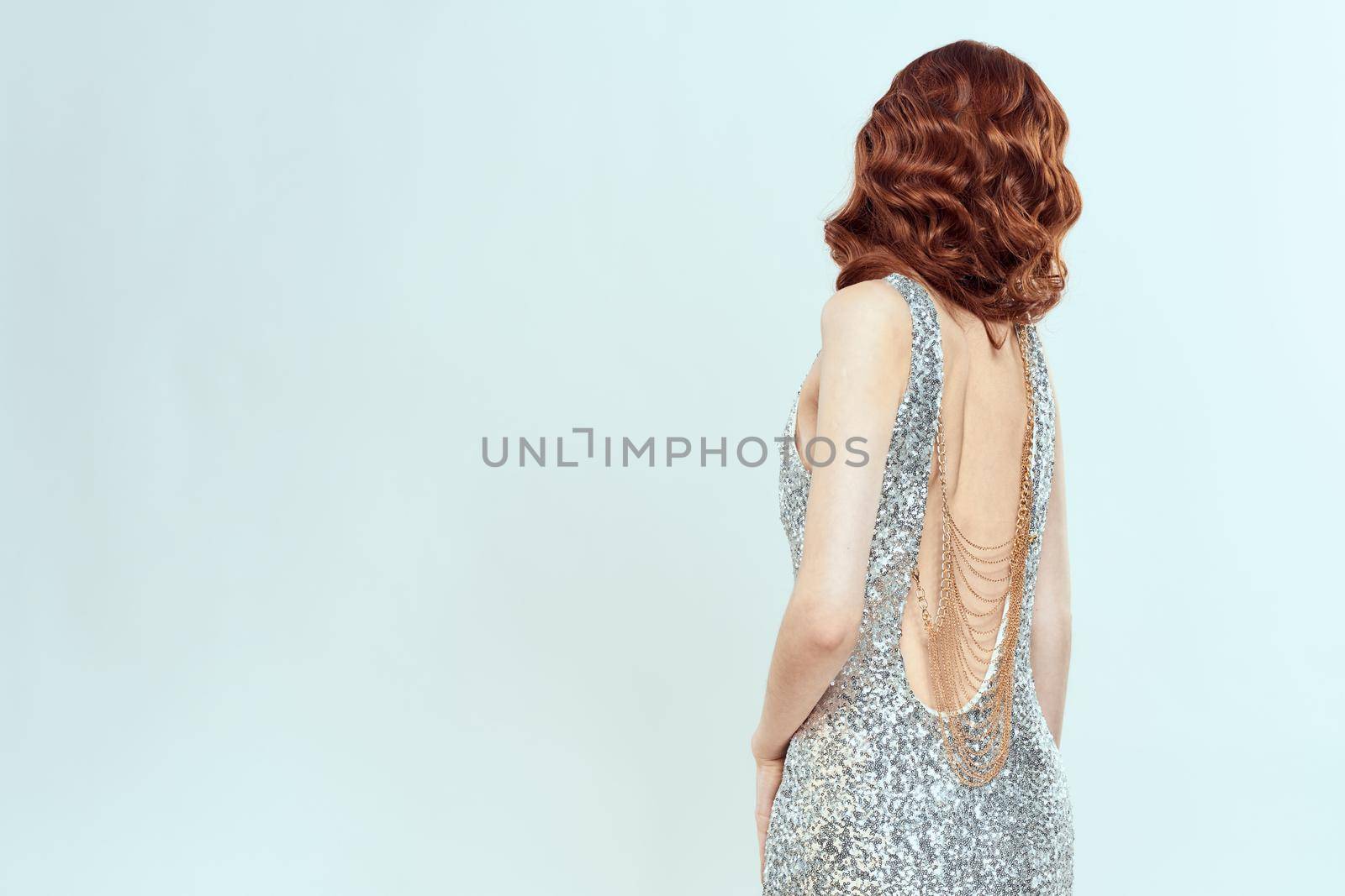 woman silver dress fashionable hairstyle from behind posing beauty. High quality photo