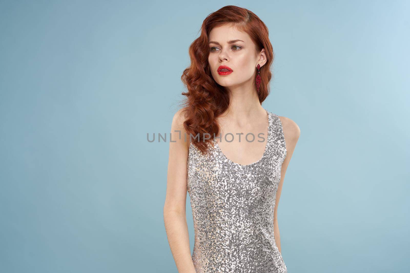 woman in silver evening dress posing blue background luxury by Vichizh