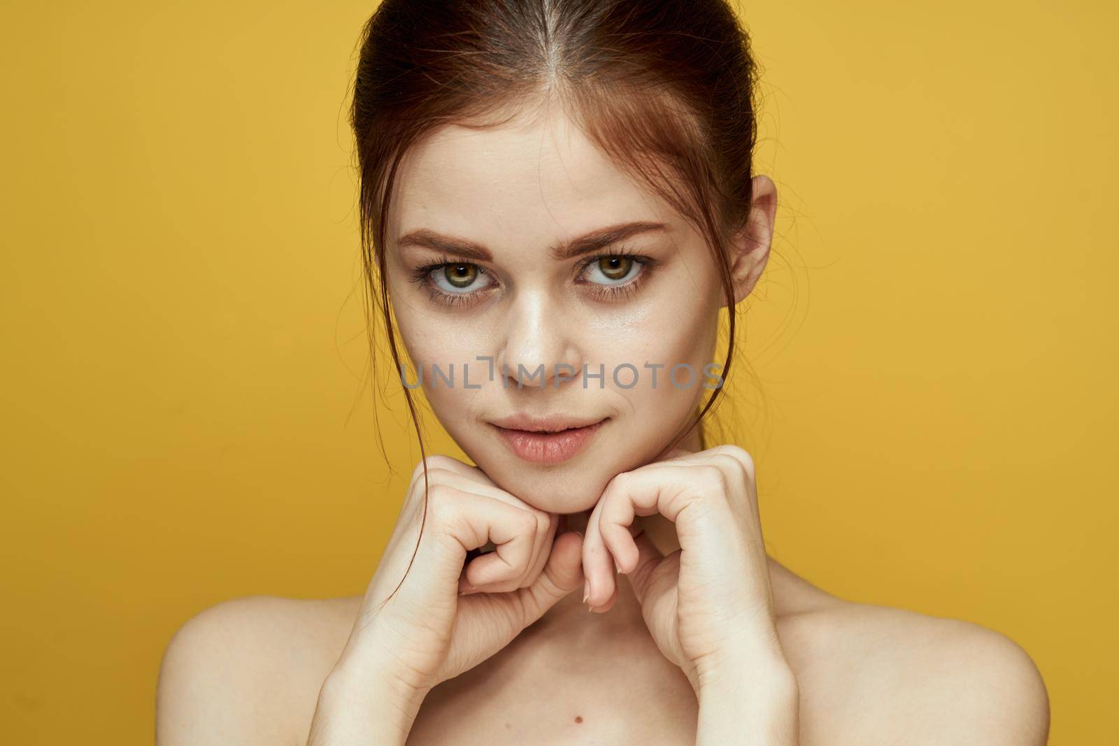 pretty woman naked shoulders and posing clear skin yellow background by Vichizh