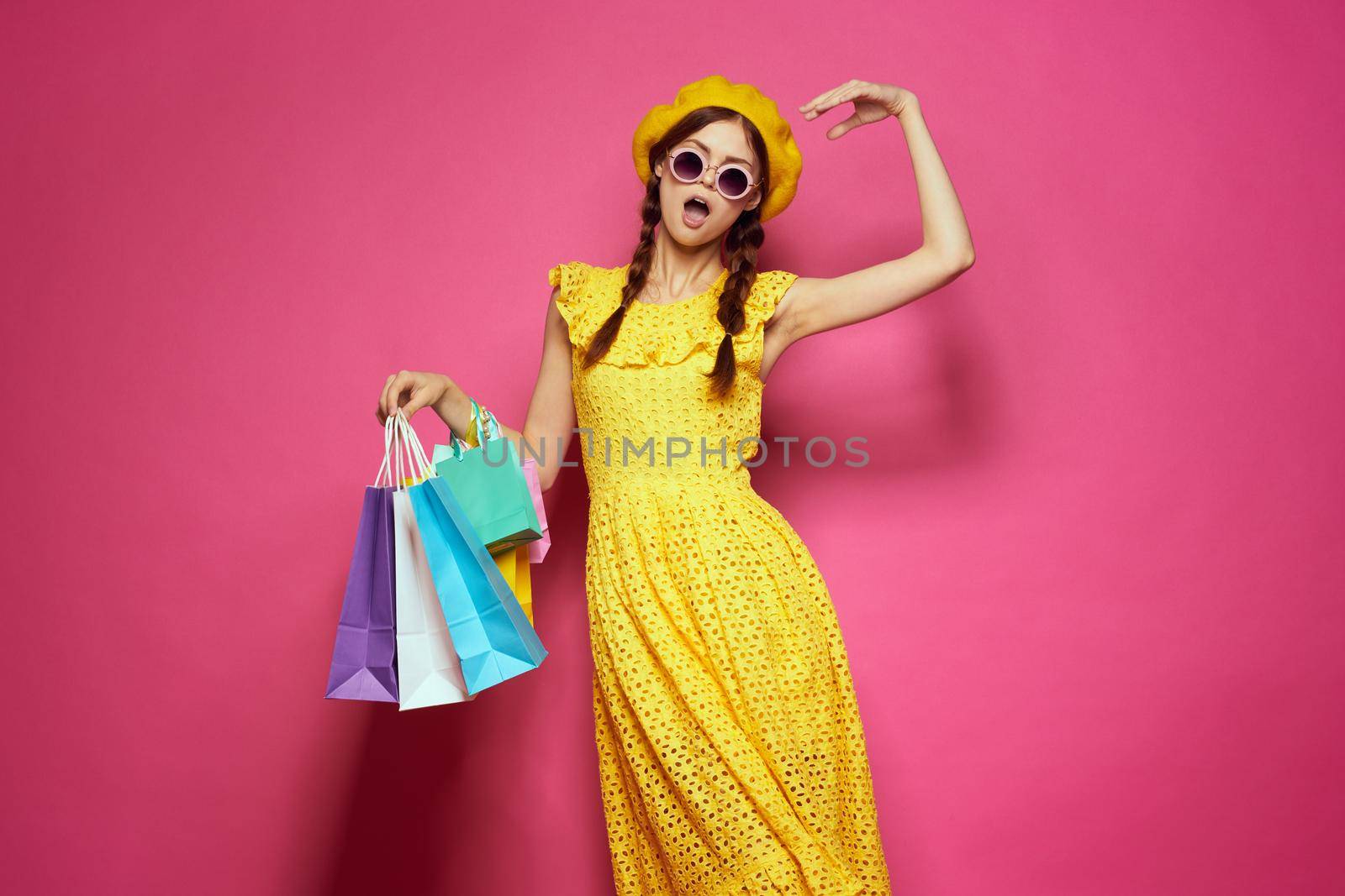 cheerful woman in a yellow hat Shopaholic fashion style pink background by Vichizh
