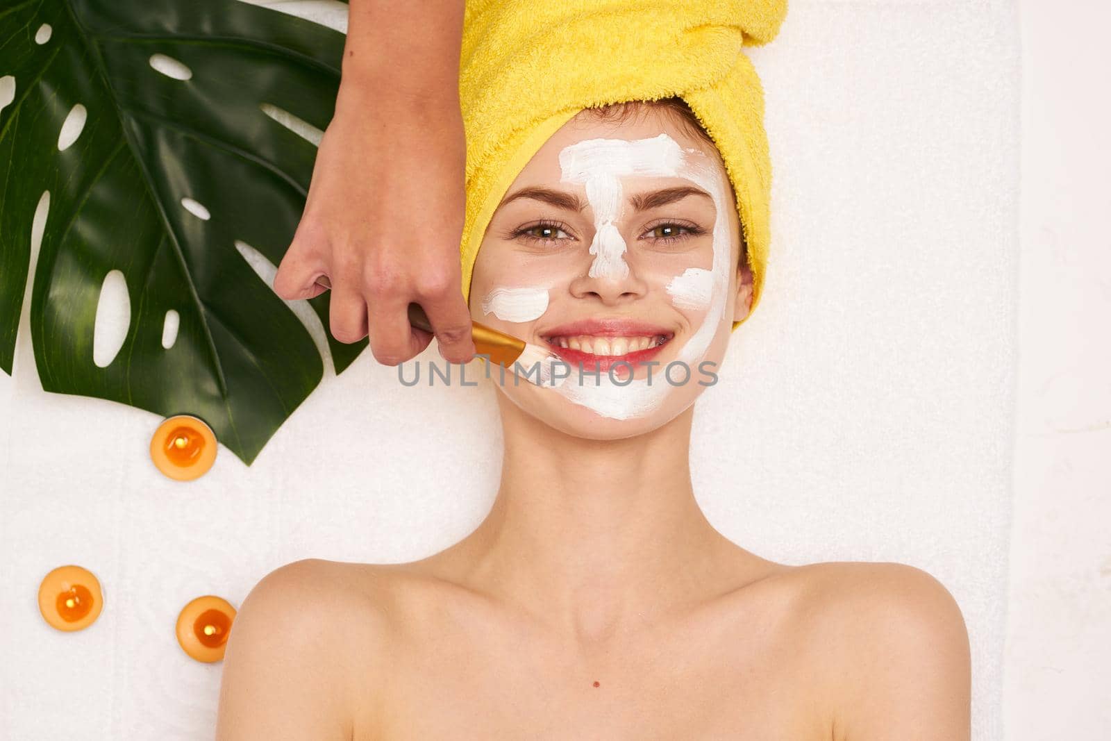 cheerful woman with a towel on my head skin care light background. High quality photo