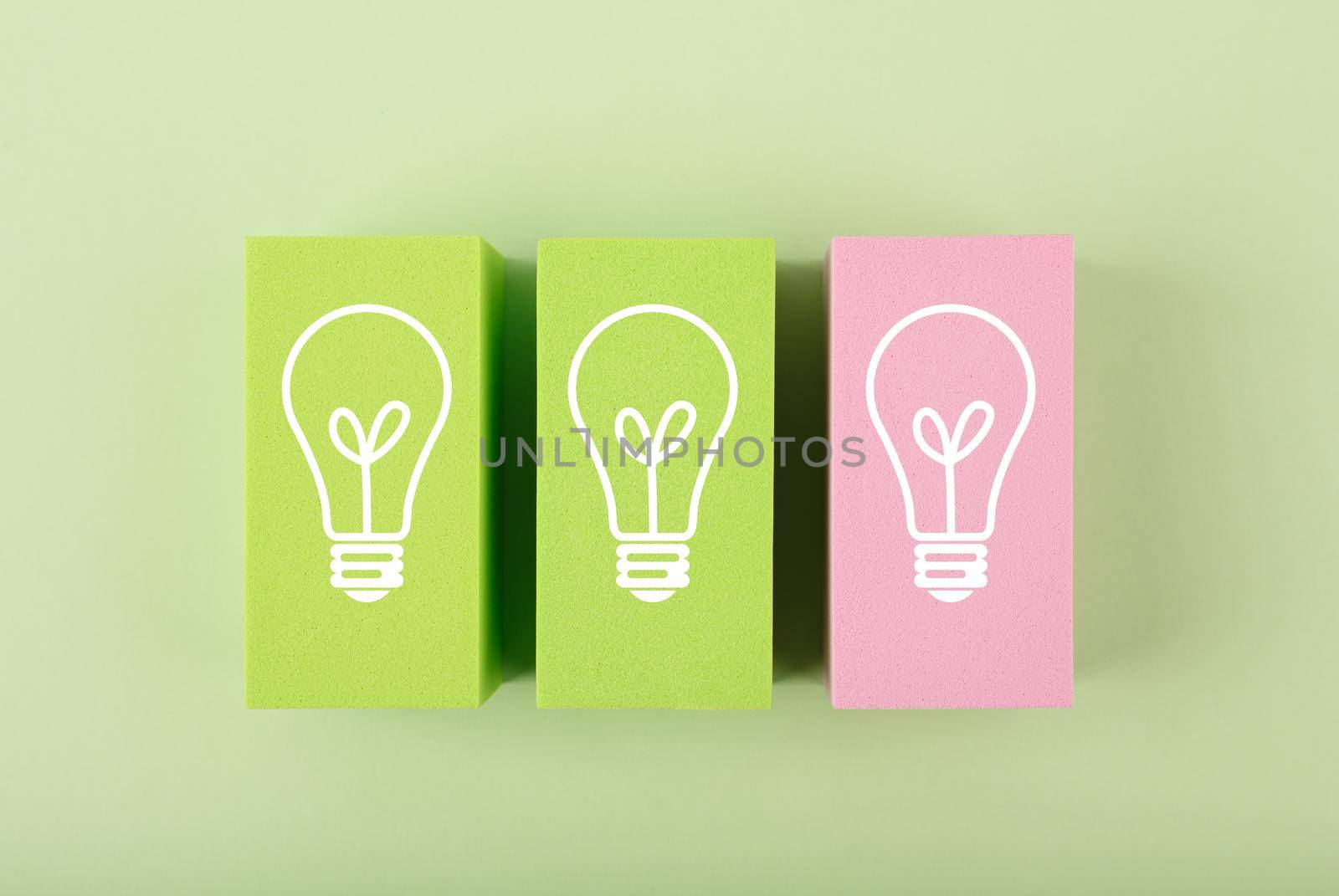 Creativity and fresh idea concept. Light bulbs on green and pink toy blocks against bright pastel green background by Senorina_Irina
