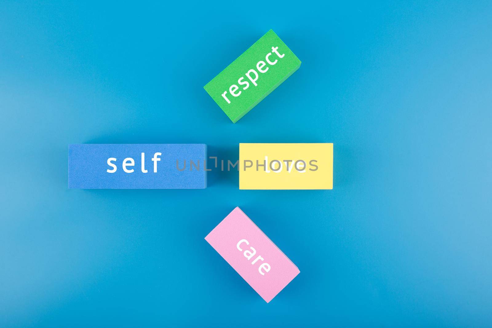 Mental health formula concept. Self respect, love and care written on multicolored rectangles on blue background by Senorina_Irina