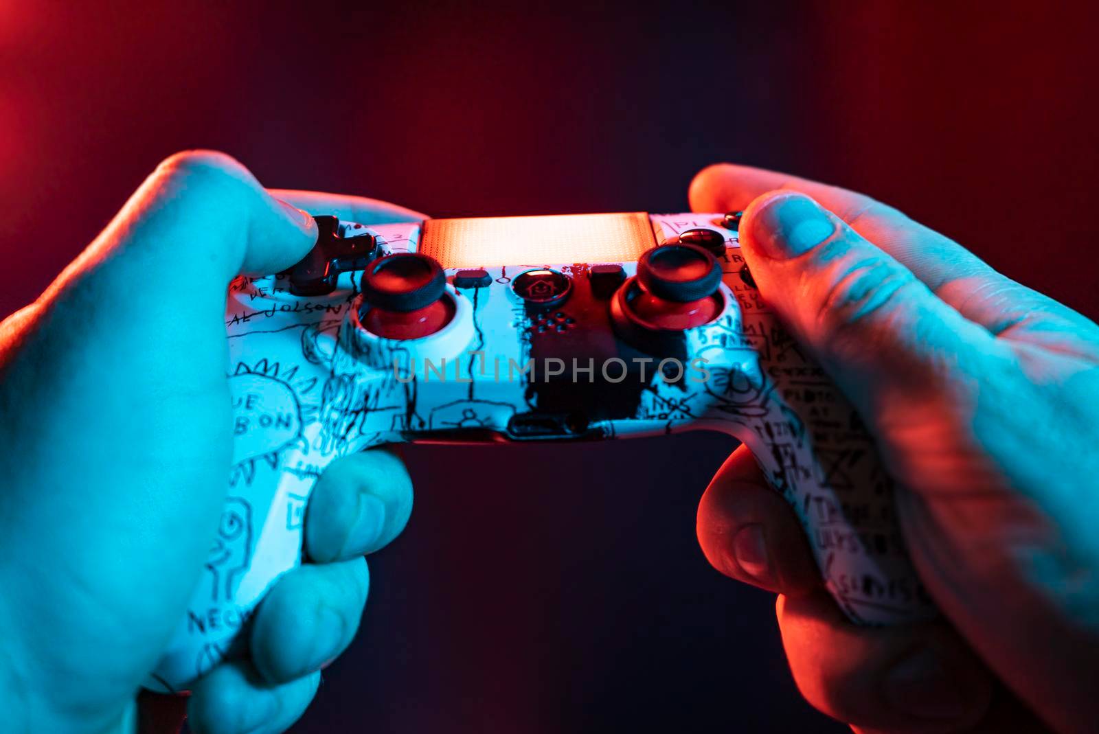 Close up of male hands playing the video game at night with joystick in hands