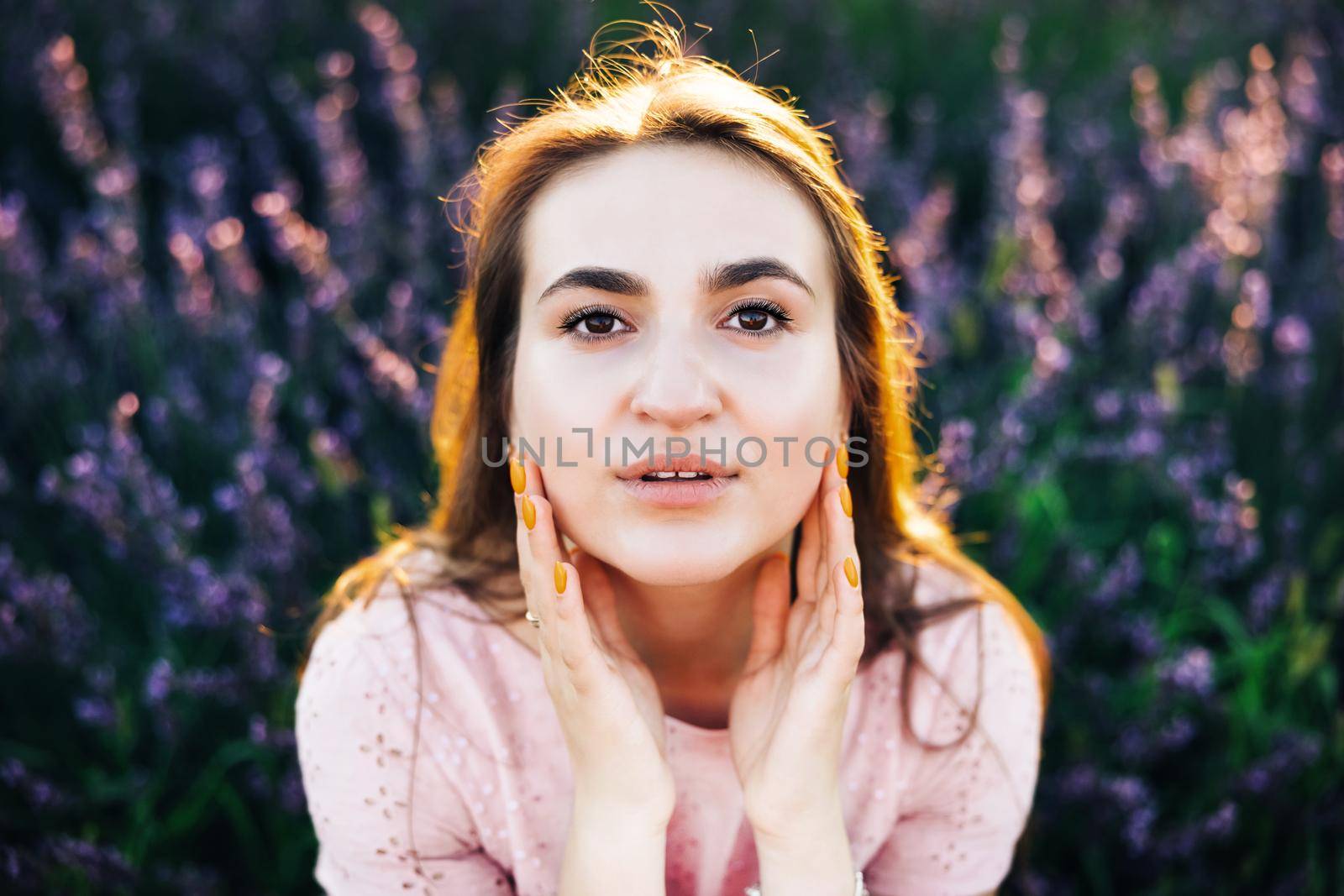 Portrait of beautiful romantic woman in fairy field of lavender. Woman on lavender field portrait. Young woman in dress outdoors. Girl in the lavender field at sunset