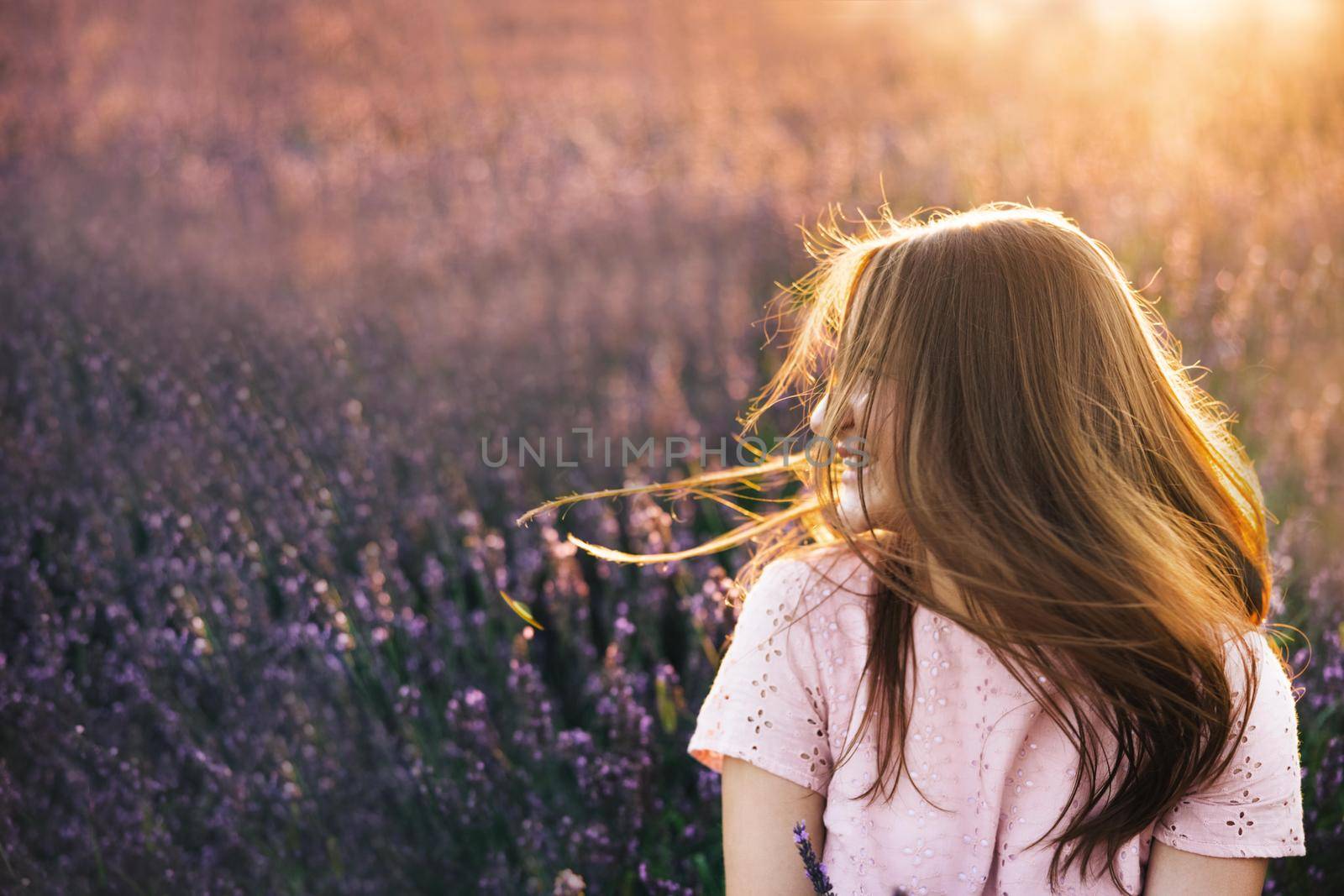 Brunette woman in dress is posing at lavender field. Lavender Fields Provence Woman sensual portraits close up at summer sunny day. Girl collect lavender