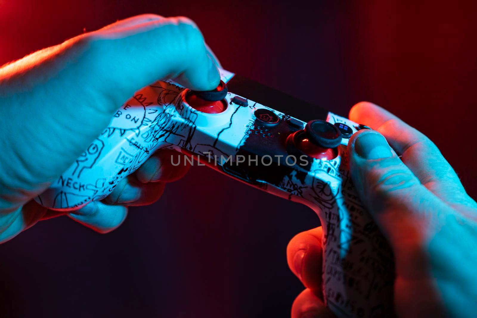 Close up of male hands playing the video game at night with joystick in hands