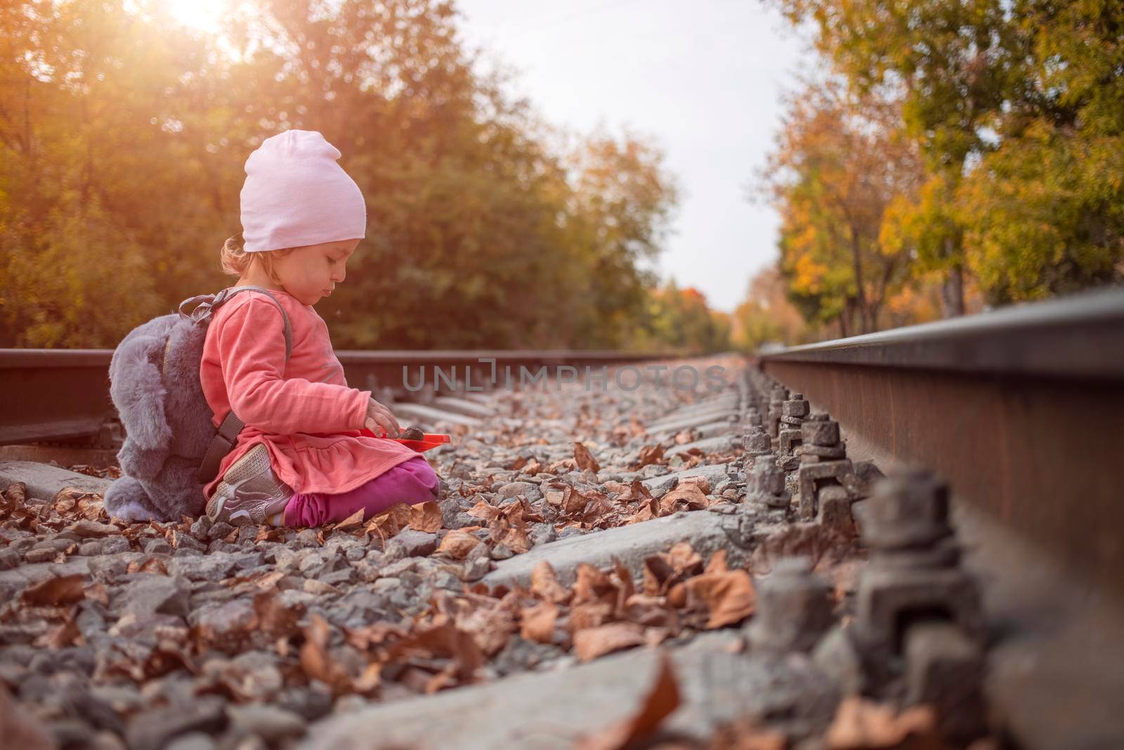 take care of children. a child plays in a dangerous place on the train tracks by Mariaprovector