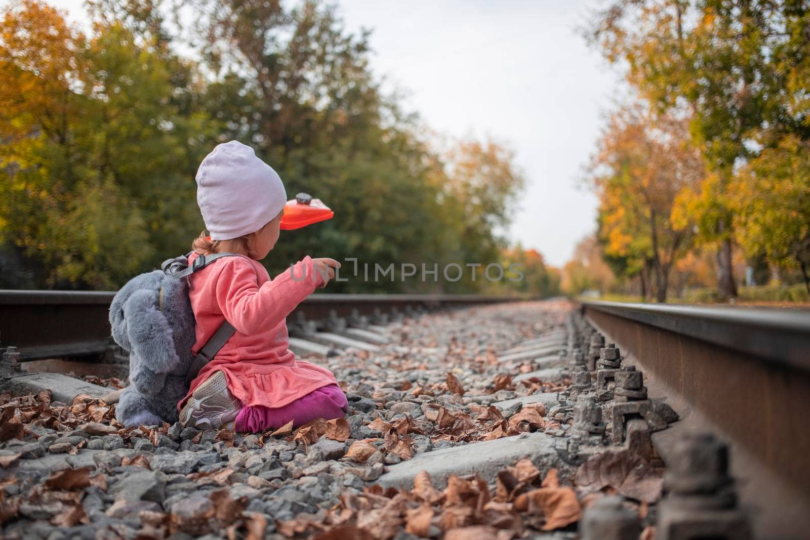 dangerous lifestyle. cute little girl plays on the railway tracks.