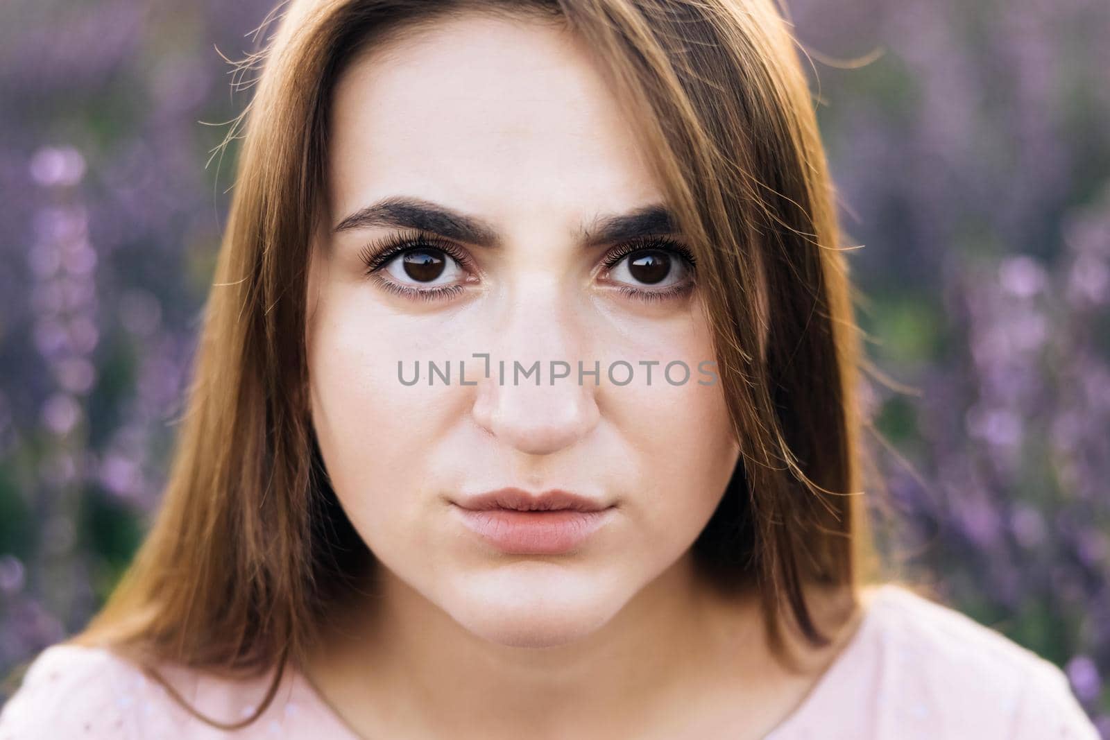 Portrait of beautiful romantic woman in fairy field of lavender. Woman on lavender field portrait. Young woman in dress outdoors.