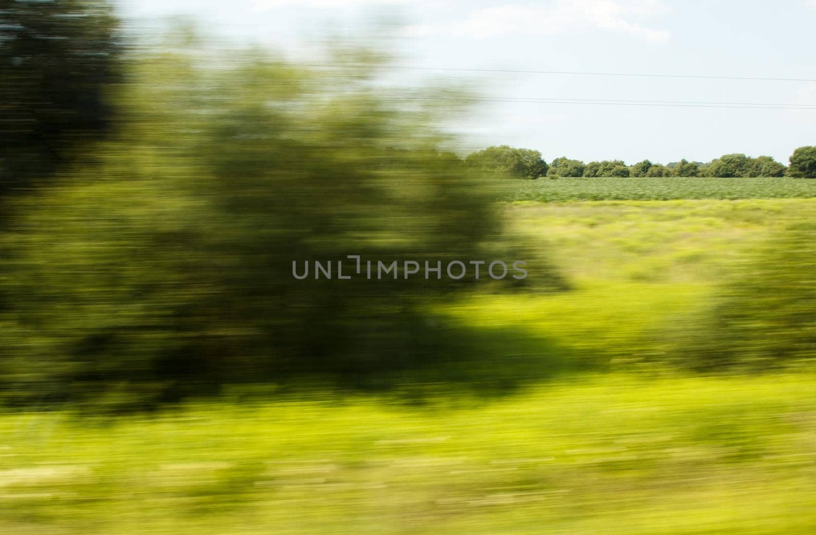 view from the window of a fast moving train on summer day