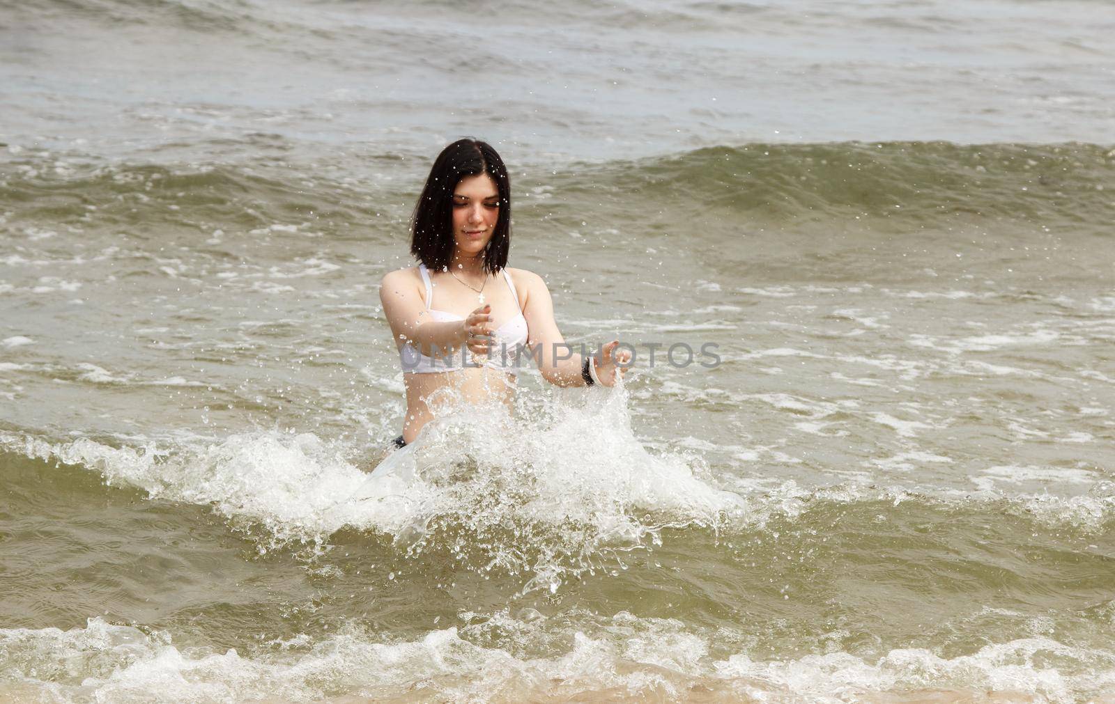 young brunette woman swiming in the sea on sunny summer day