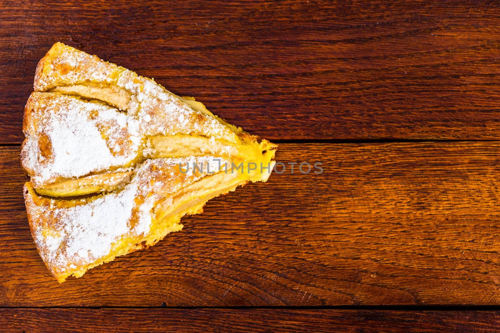 Sliced apple pie with cinnamon on rustic wooden table by vladispas