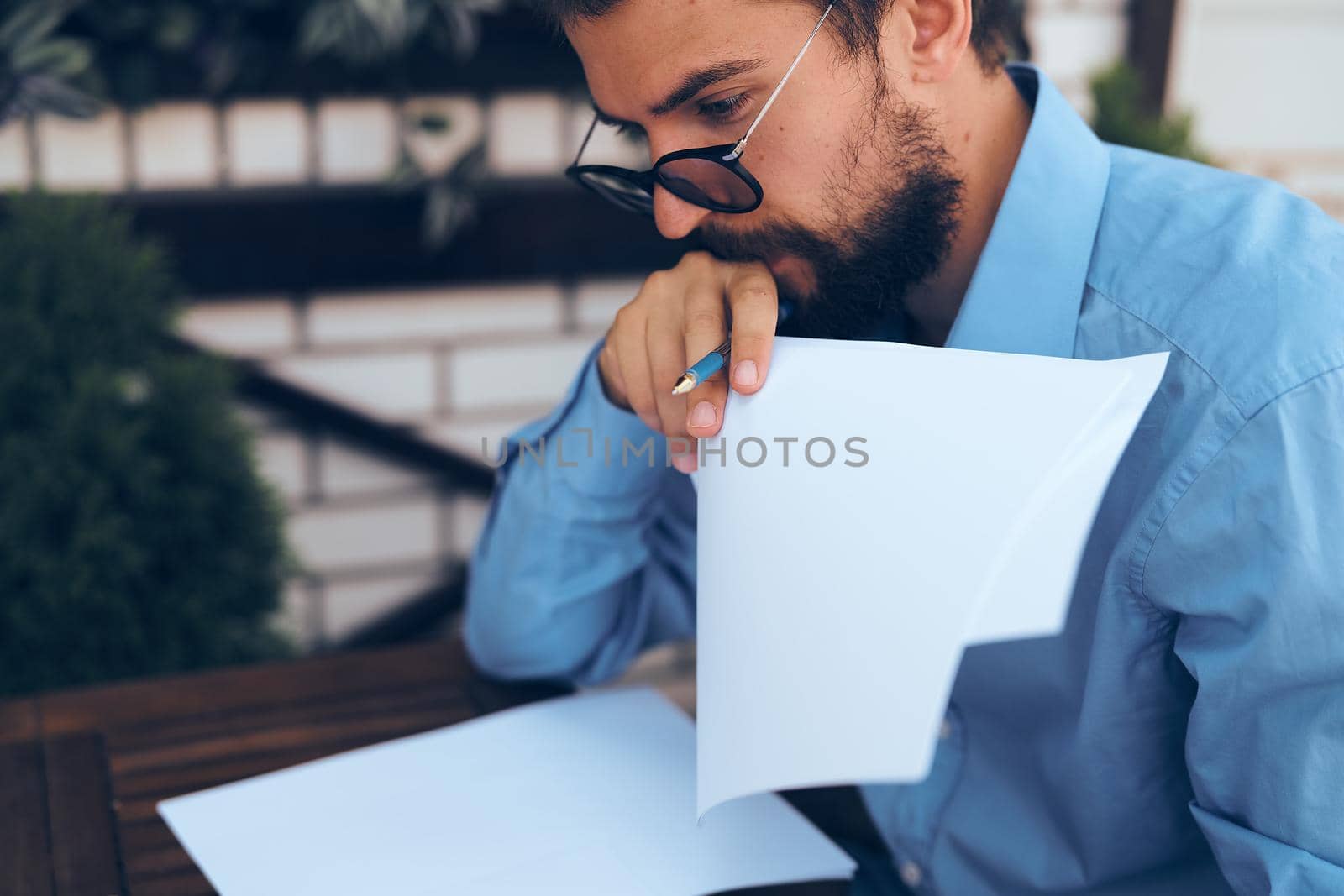 man in blue shirt in summer cafe paper work lifestyle. High quality photo