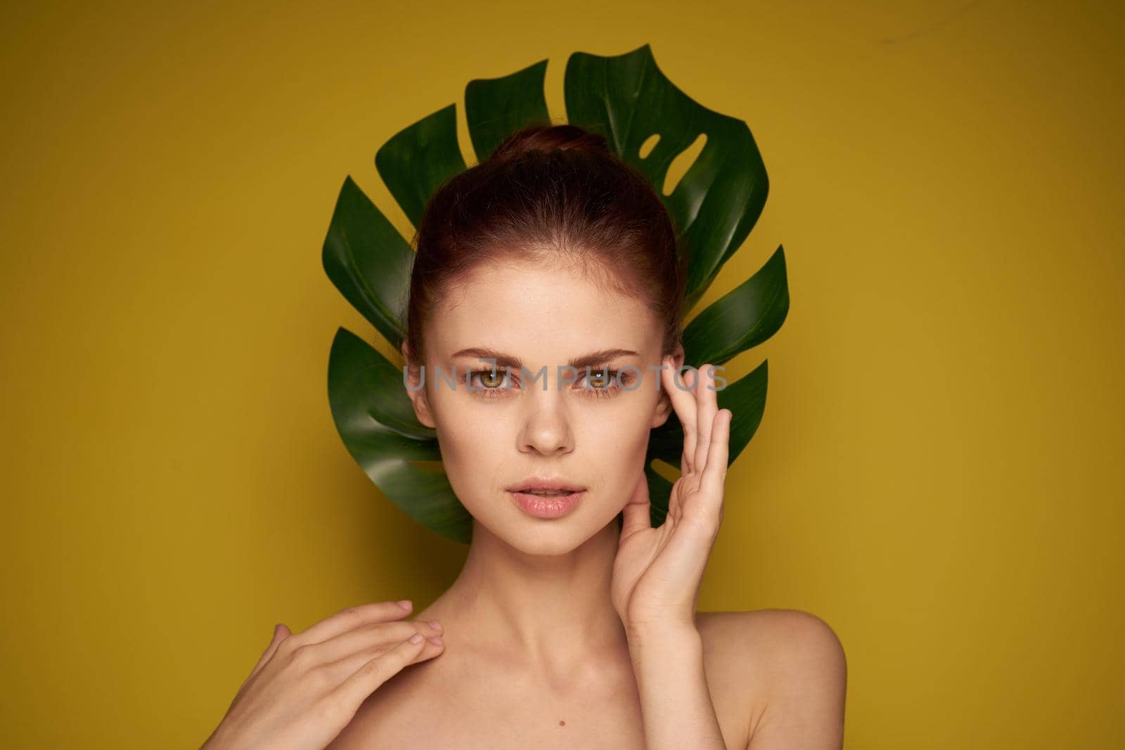 pretty woman clean skin palm leaf cosmetics studio model. High quality photo