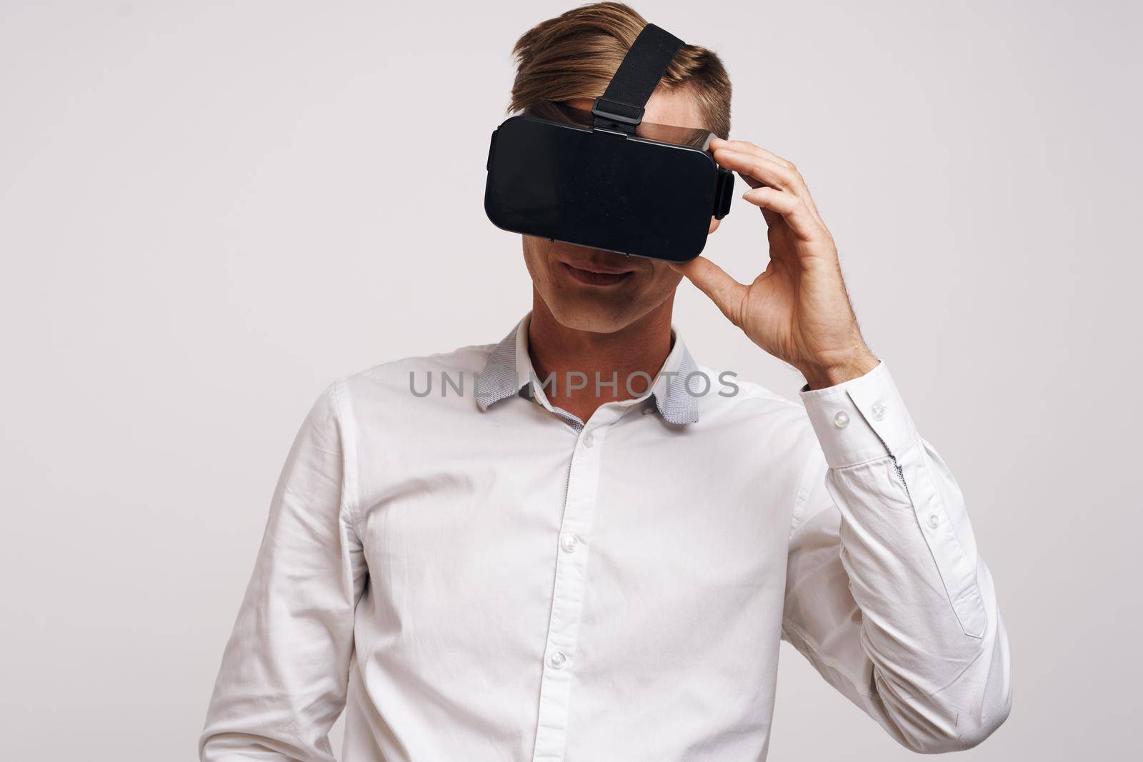 Cheerful man virtual reality glasses high-tech simulator technology studio by Vichizh
