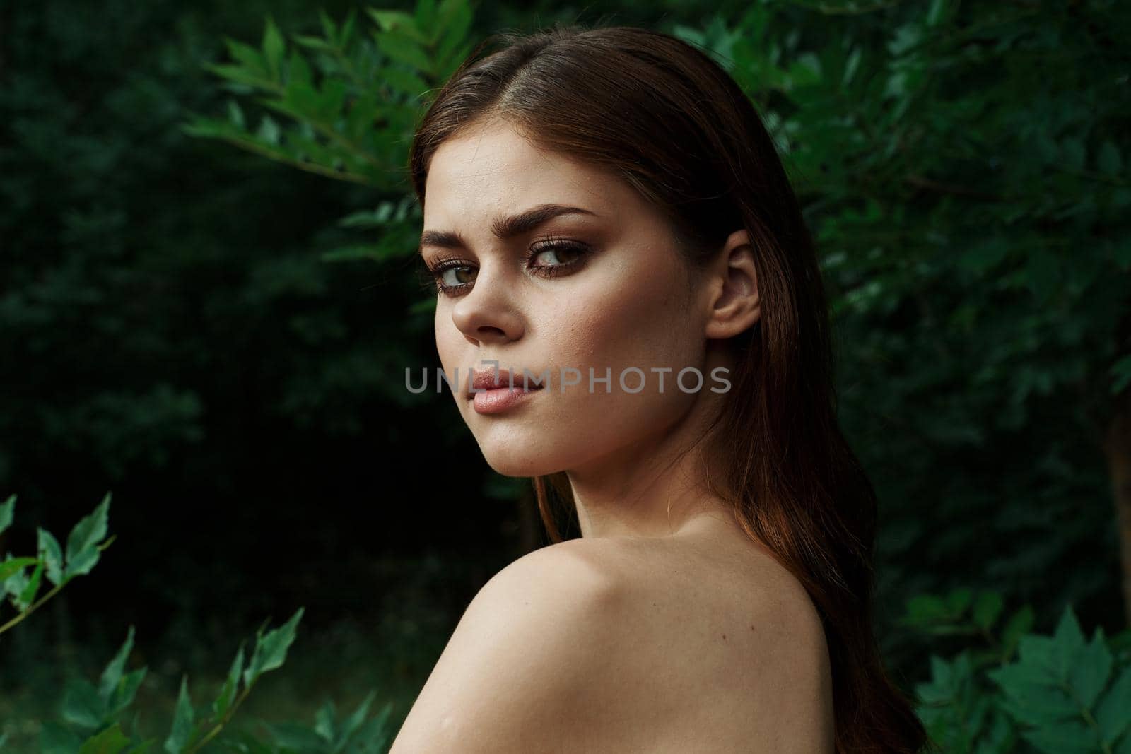 portrait of a woman bared shoulders green bush cosmetics Lifestyle. High quality photo