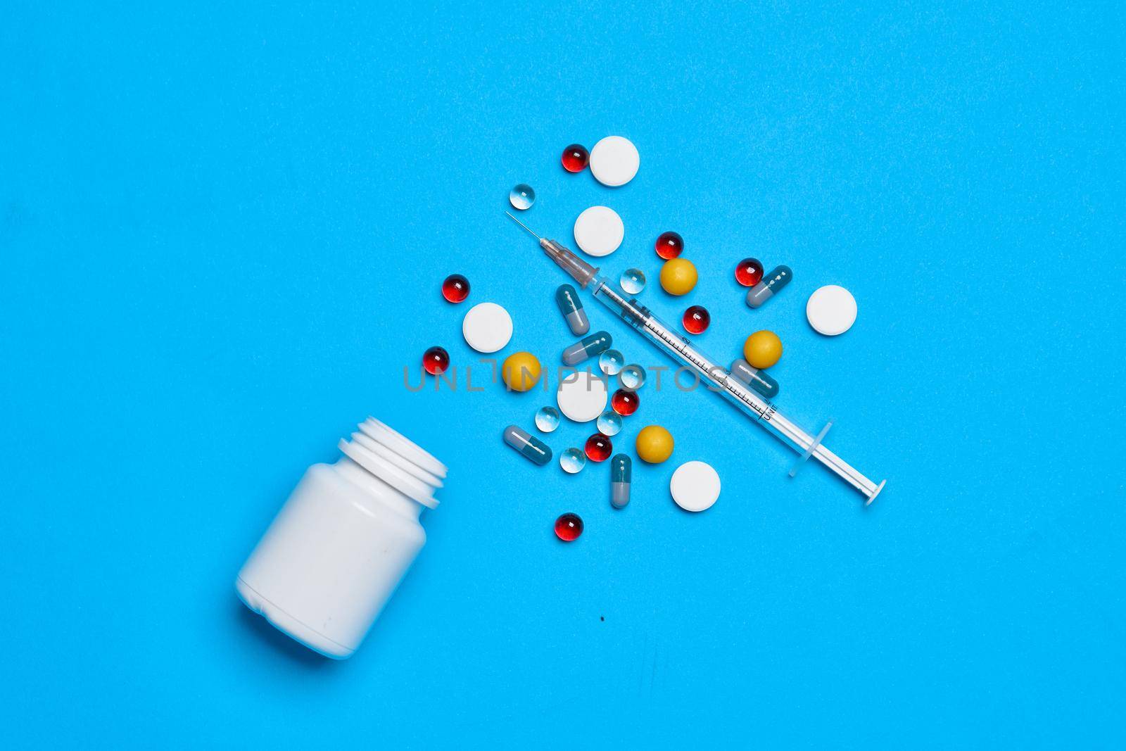 multicolored pills vitamins capsules medicine blue background. High quality photo