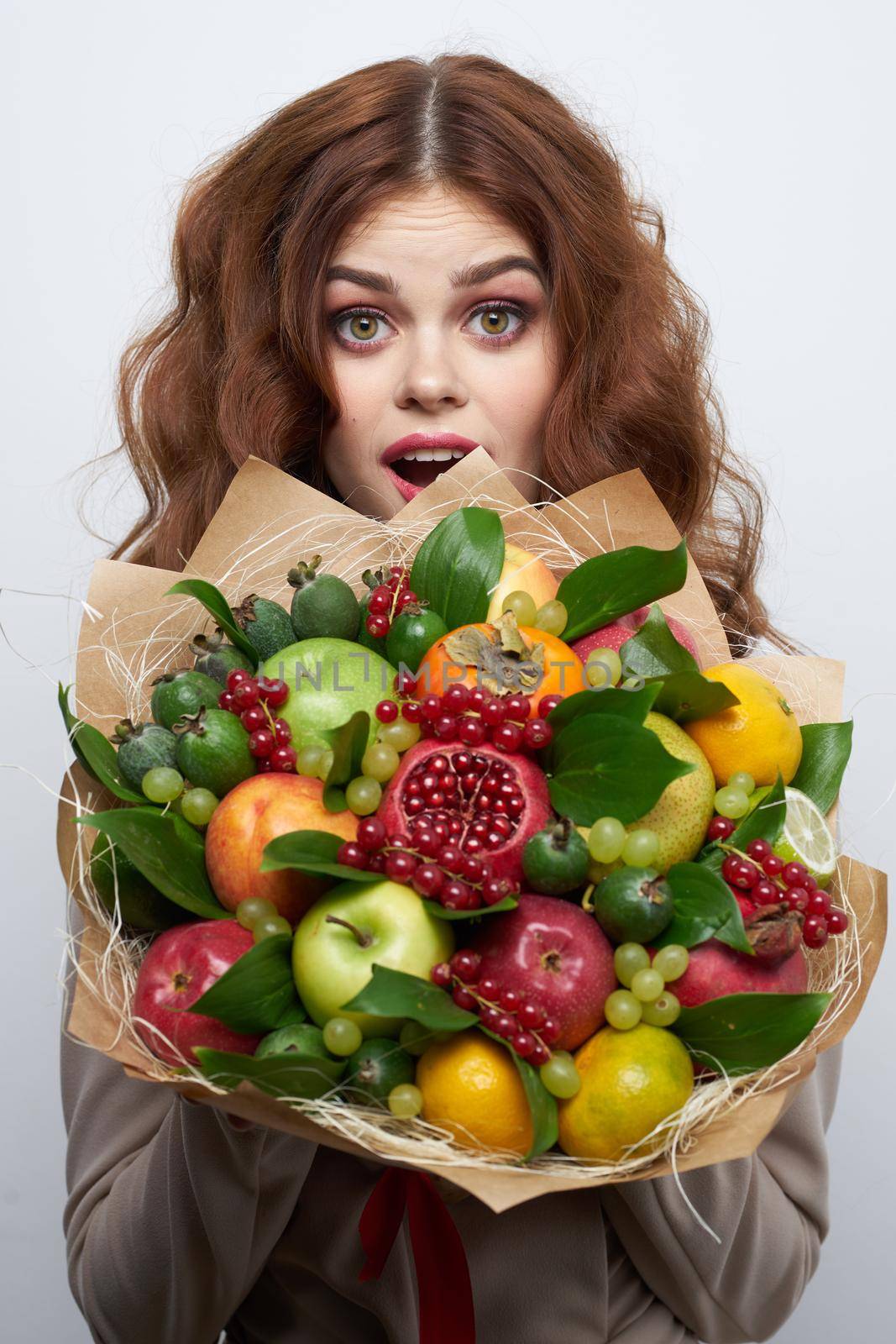 portrait of a woman fun posing fruit bouquet vitamins light background by Vichizh
