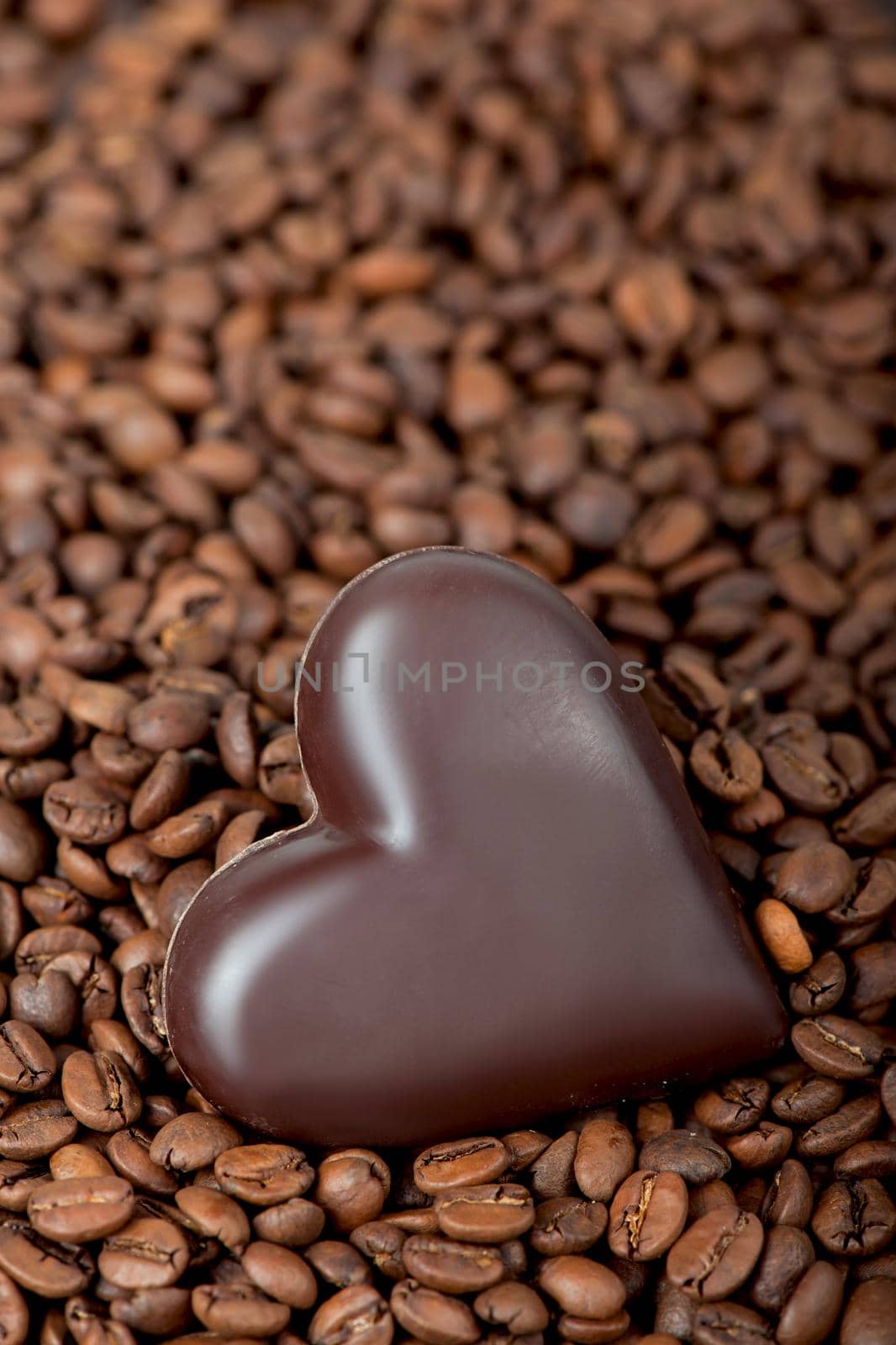 Coffee beans heart with heart-shaped candy .