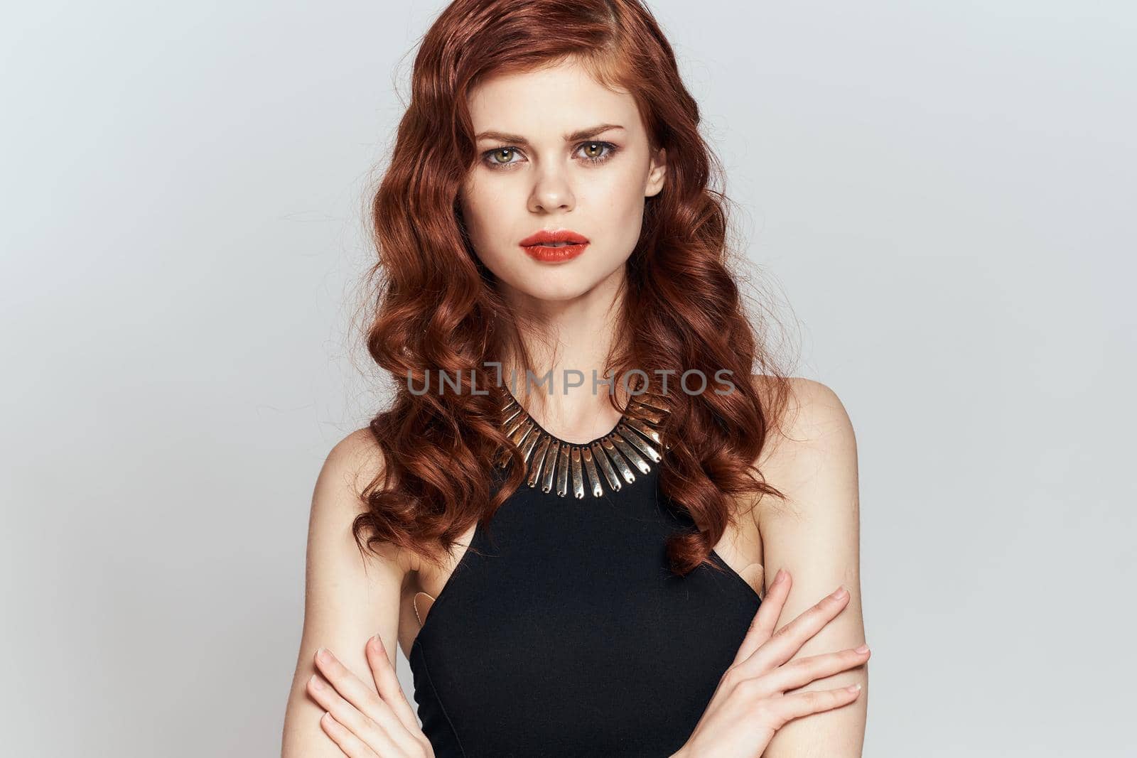 red-haired woman in black dress red lips glamor posing. High quality photo