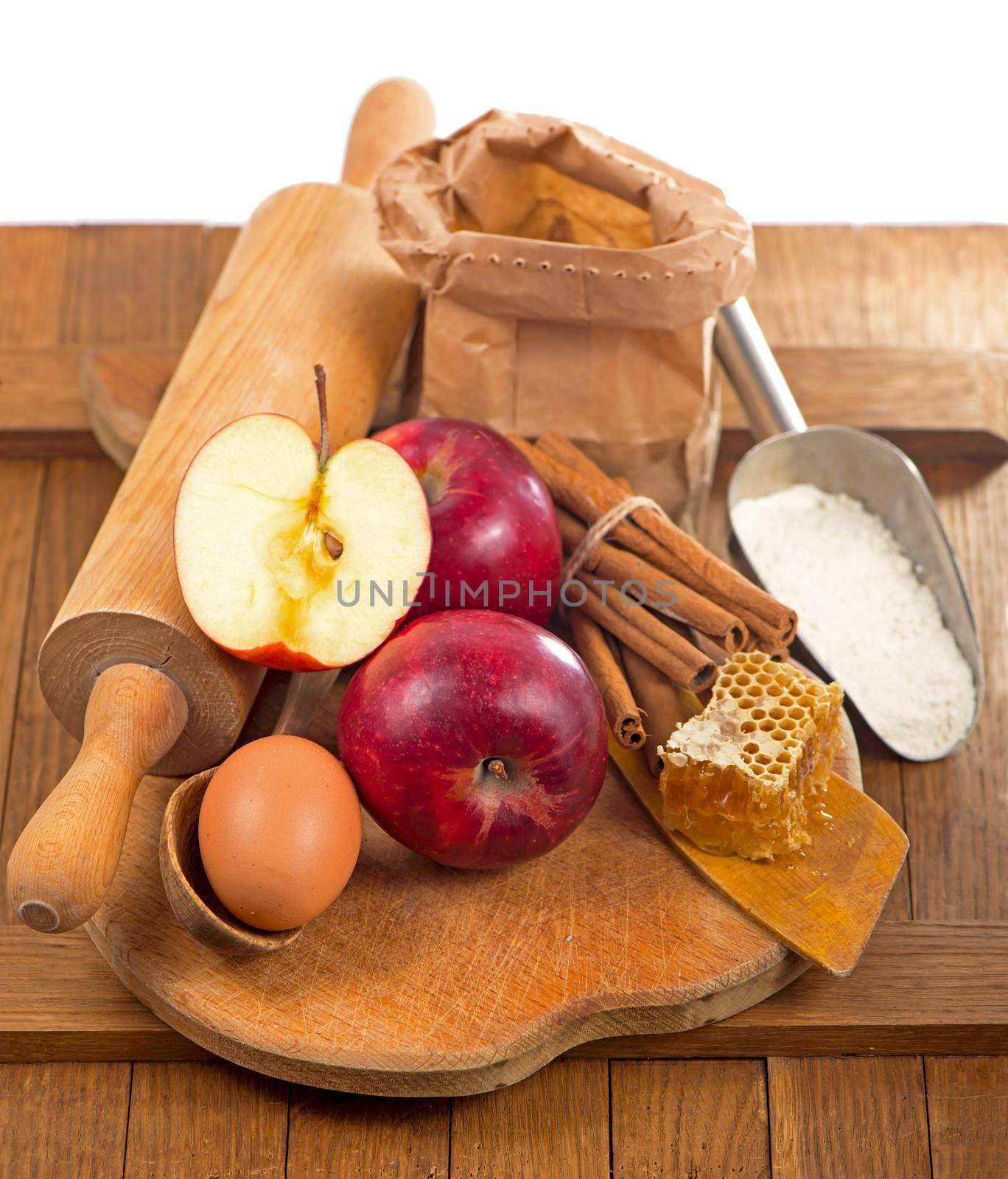 honey spoon, jar of honey, apples and cinnamon on a wooden background in a rustic style by aprilphoto