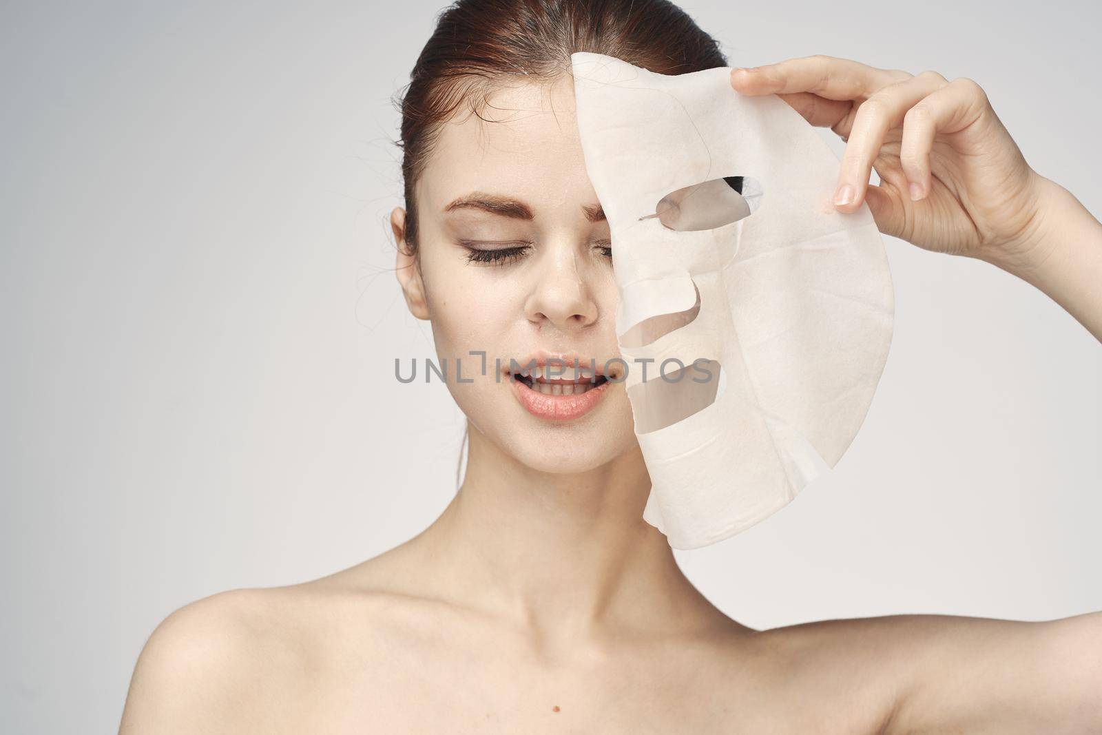 woman with bare shoulders and face mask skin care cosmetics. High quality photo