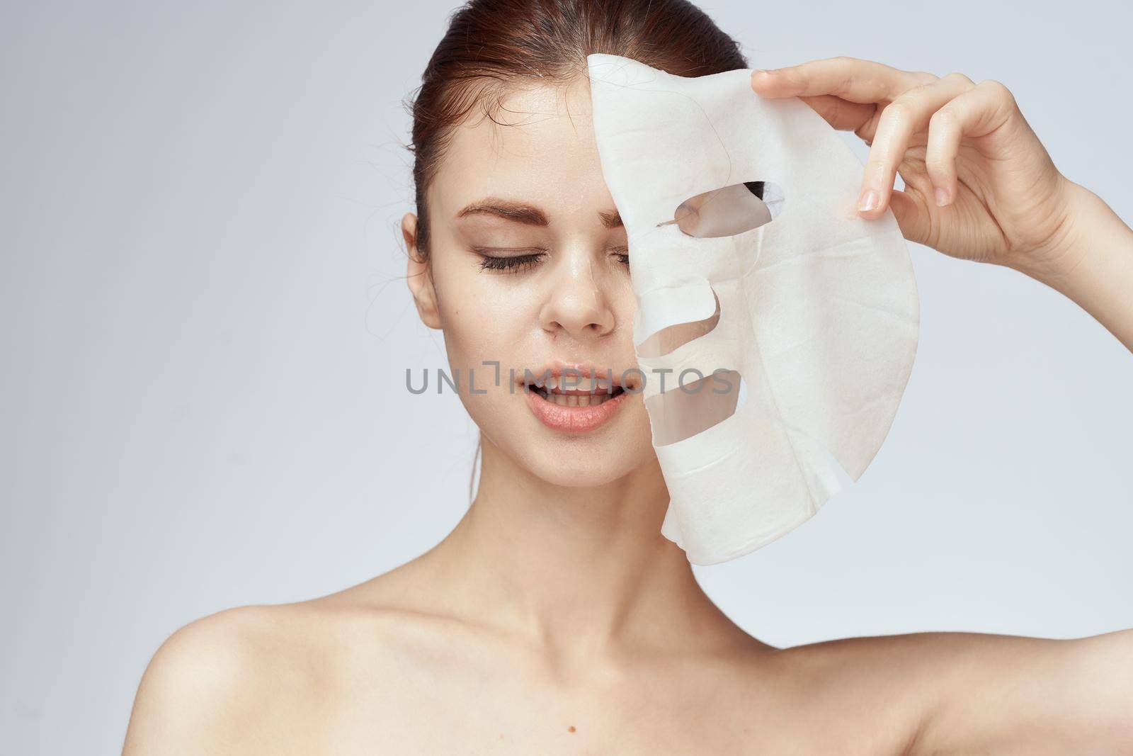 woman with bare shoulders and face mask skin care cosmetics. High quality photo