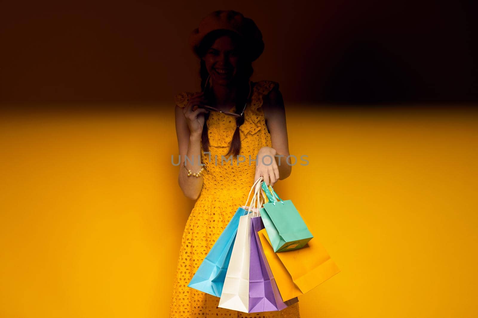 glamorous woman yellow dress shopping fun isolated background. High quality photo