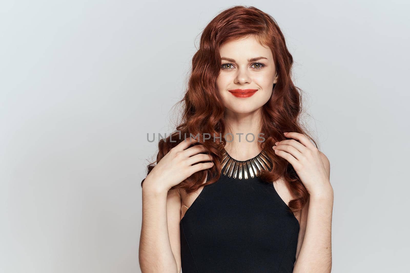 red-haired woman in black dress red lips glamor posing. High quality photo