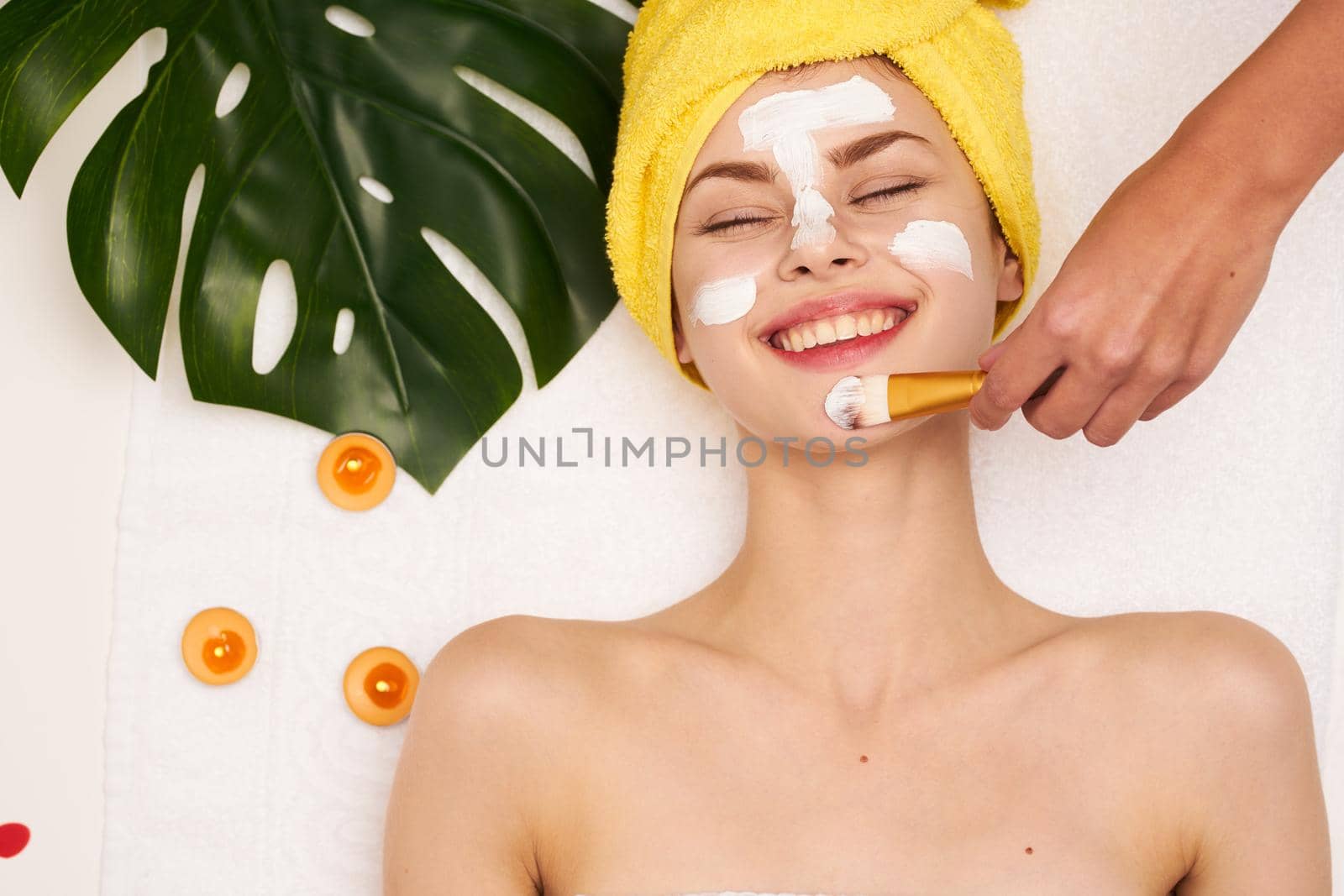 pretty woman face mask skin cleansing palm leaf light background. High quality photo