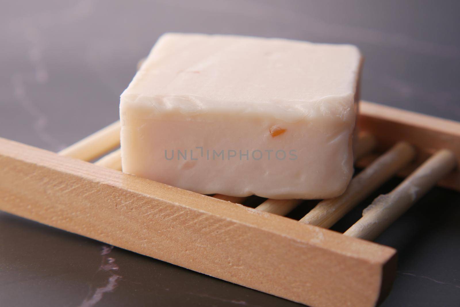 Homemade natural soap bar on black background .