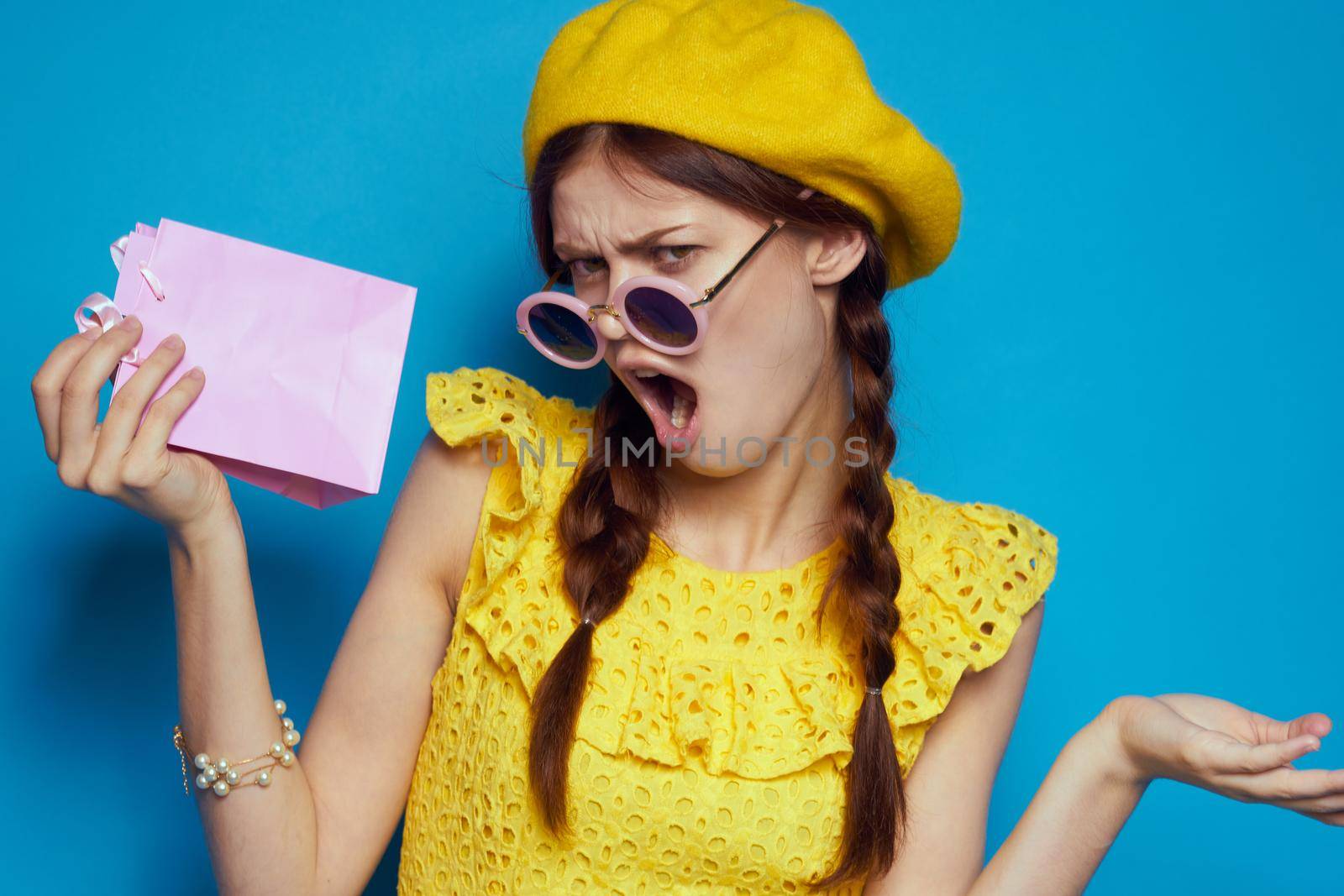 glamorous woman in a yellow hat Shopaholic fashion style blue background. High quality photo