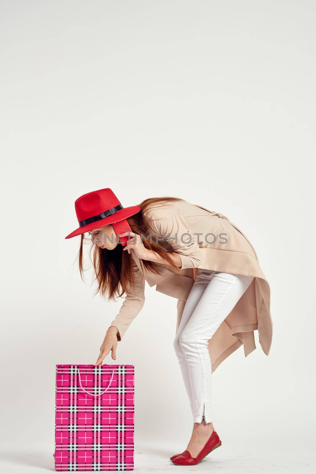 cheerful woman wearing a red hat posing shopping fun light background. High quality photo