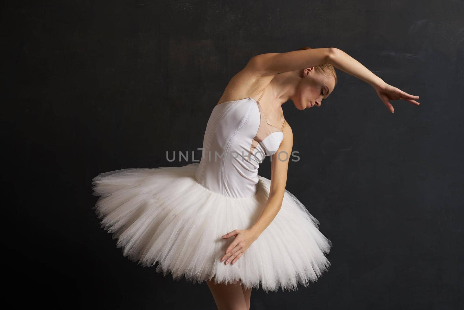 ballerina in a white tutu dance performance silhouette dark background. High quality photo